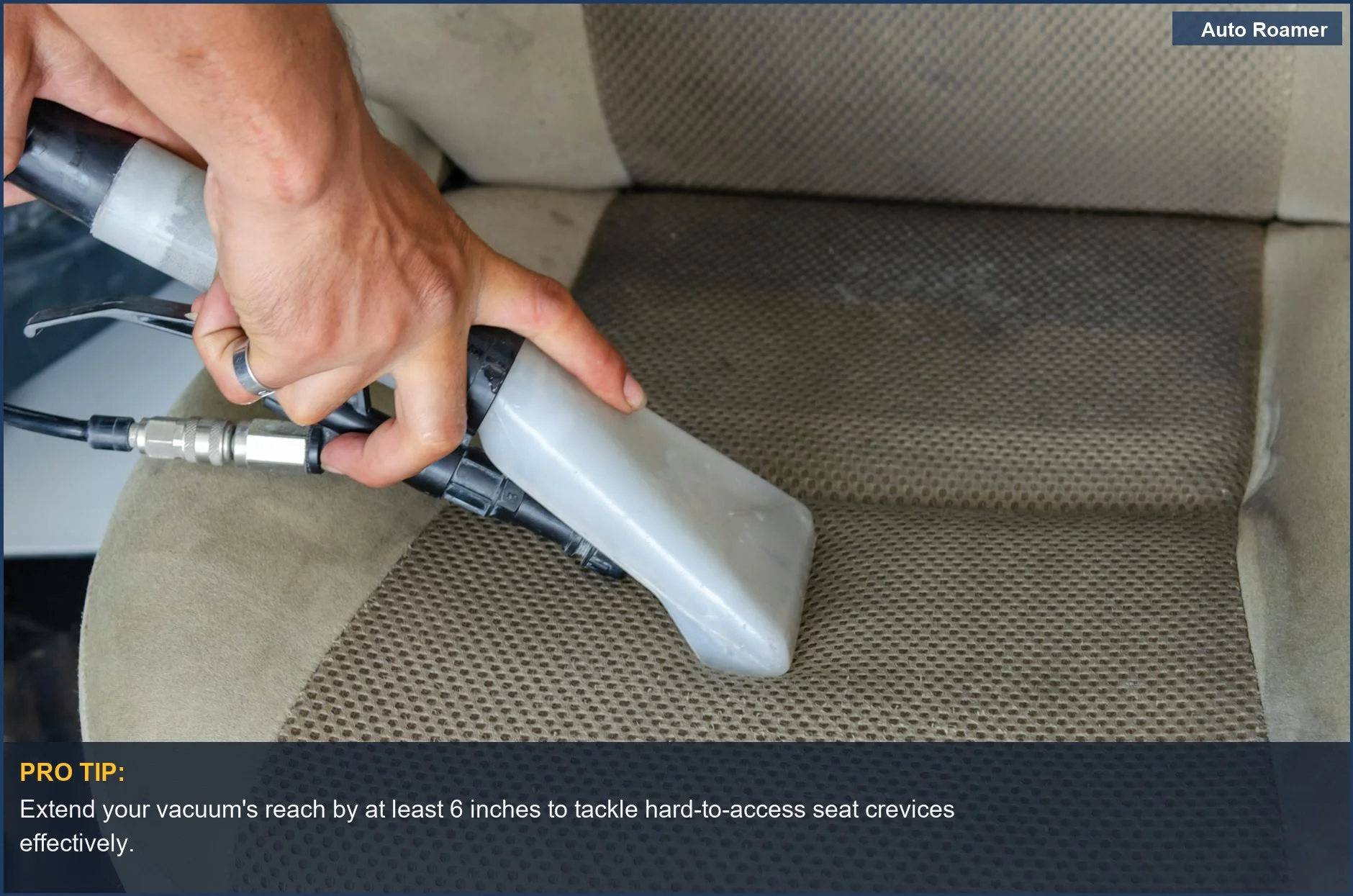 Hands using a cordless car vacuum crevice tool to clean deep fabric car seat dirt and stains.