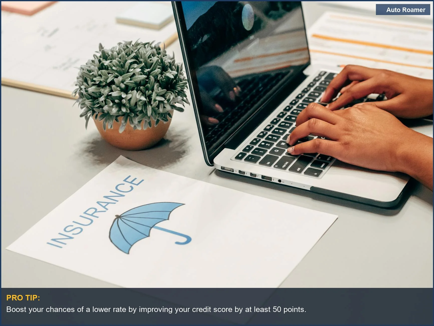 Manos escribiendo en un portátil con documentos de seguro, mostrando la conexión entre el trabajo y el seguro de coche basado en el crédito.