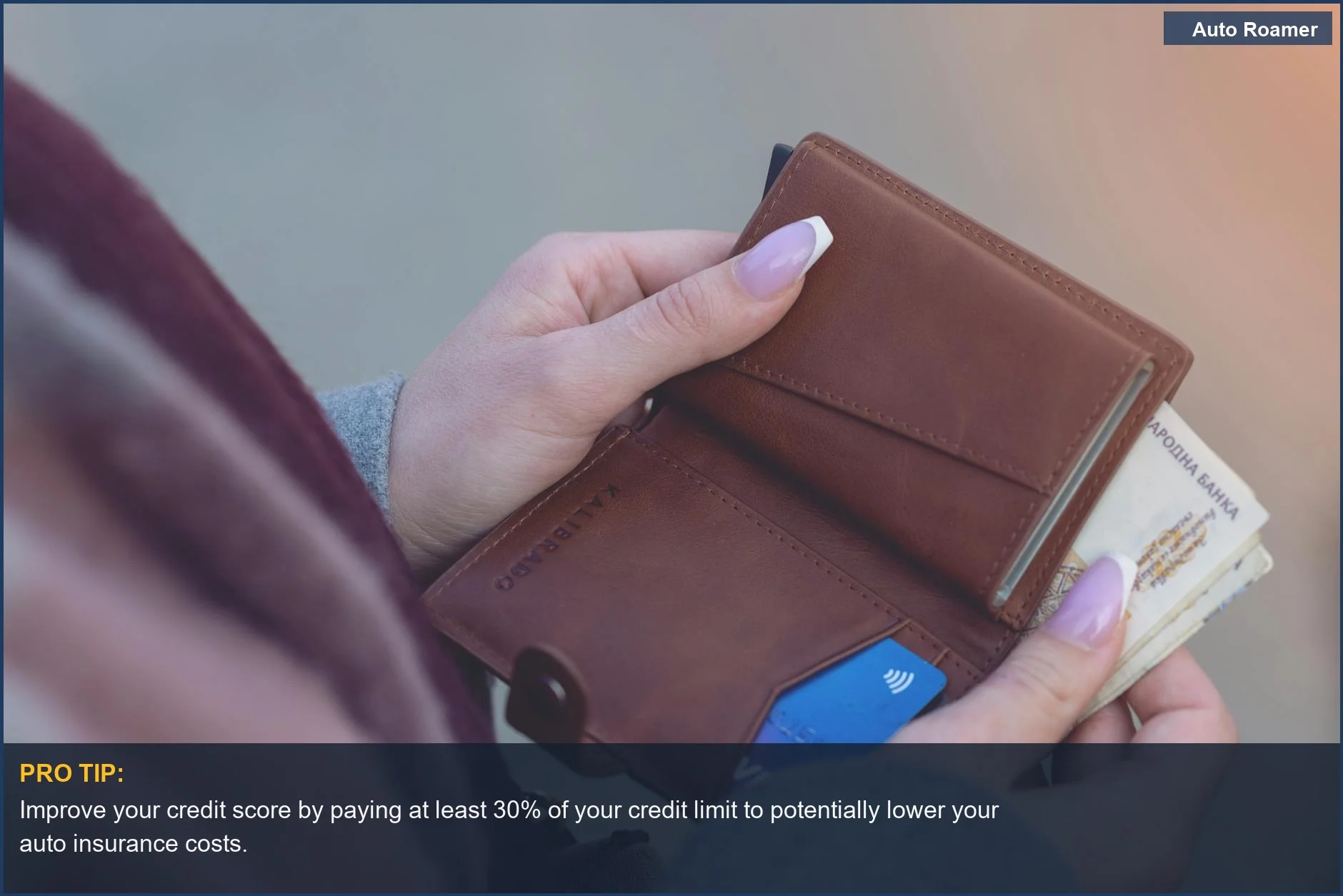 Hands holding a wallet with banknotes and a credit card, showing the connection between credit and auto insurance.
