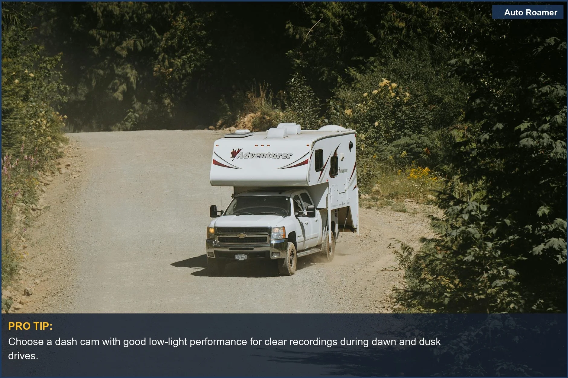 White camper truck on a winding dirt road in a forest, showcasing dash cam features for camping.