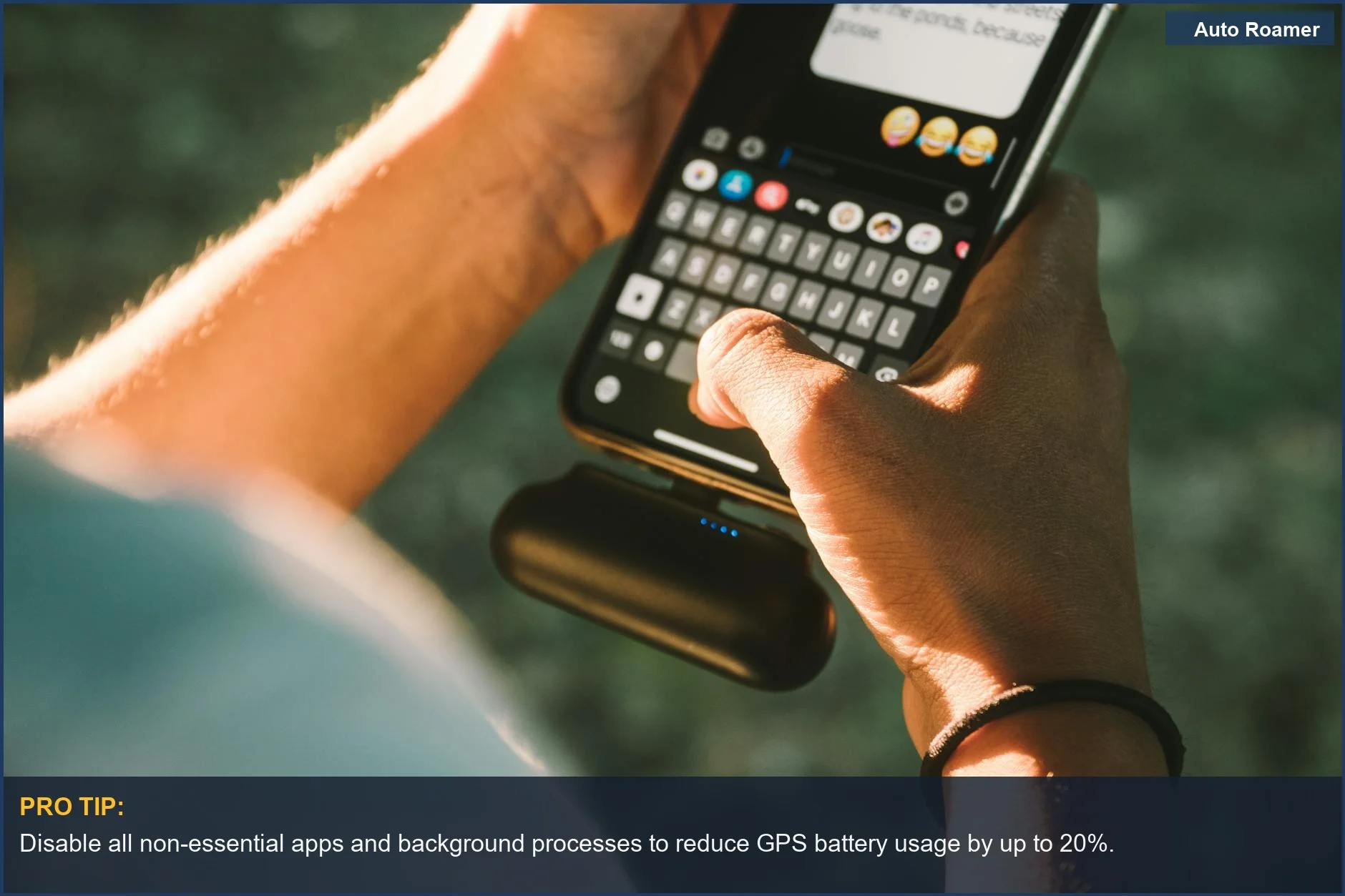 Persona enviando mensajes de texto en un teléfono conectado a una batería externa al aire libre, demostrando el impacto del uso de la batería del GPS.
