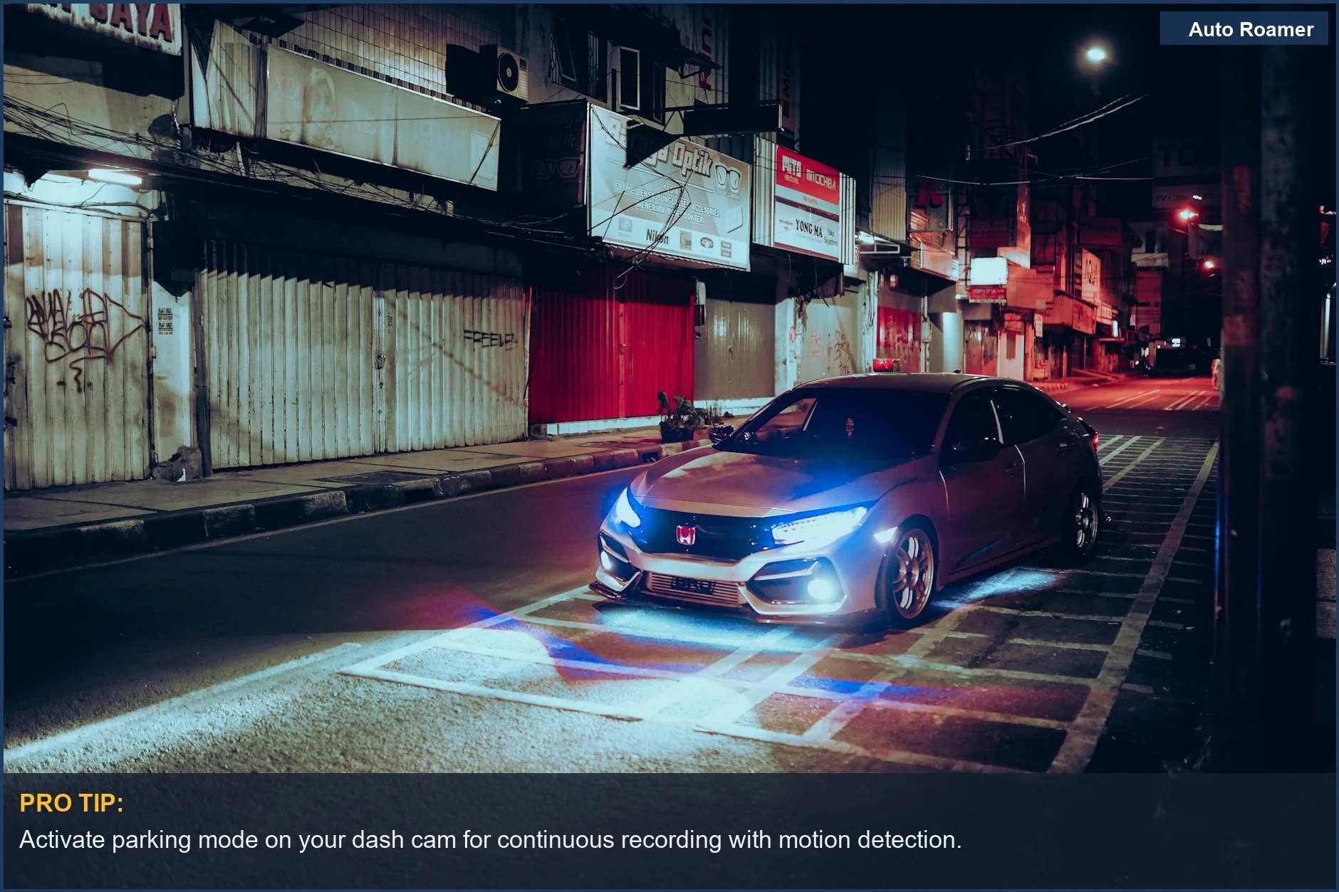 Car with illuminated headlights on an empty urban street, showcasing car security camera potential.
