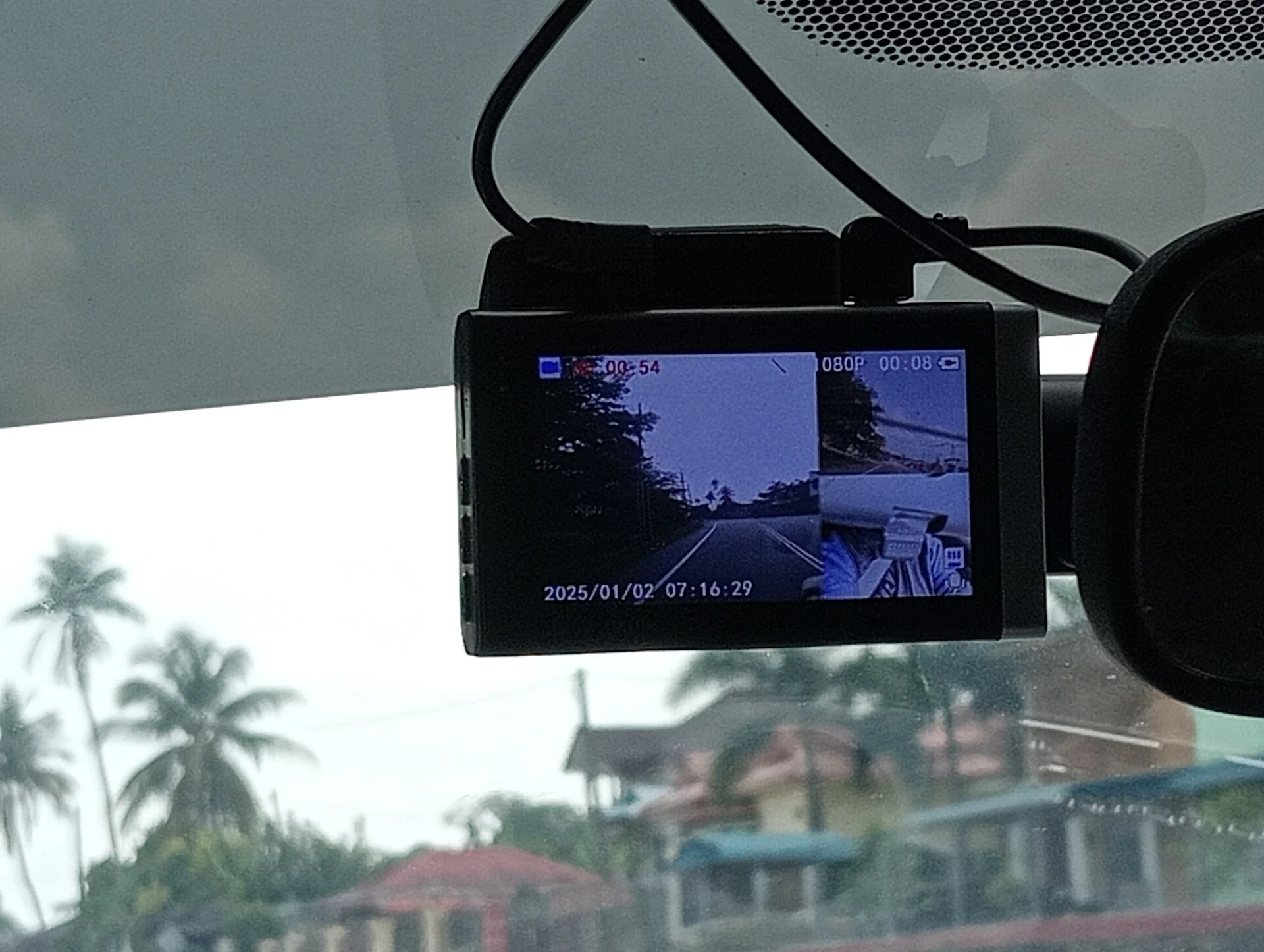 A windshield-mounted dash cam with its screen active, the device this guide restores a lost GPS signal on.