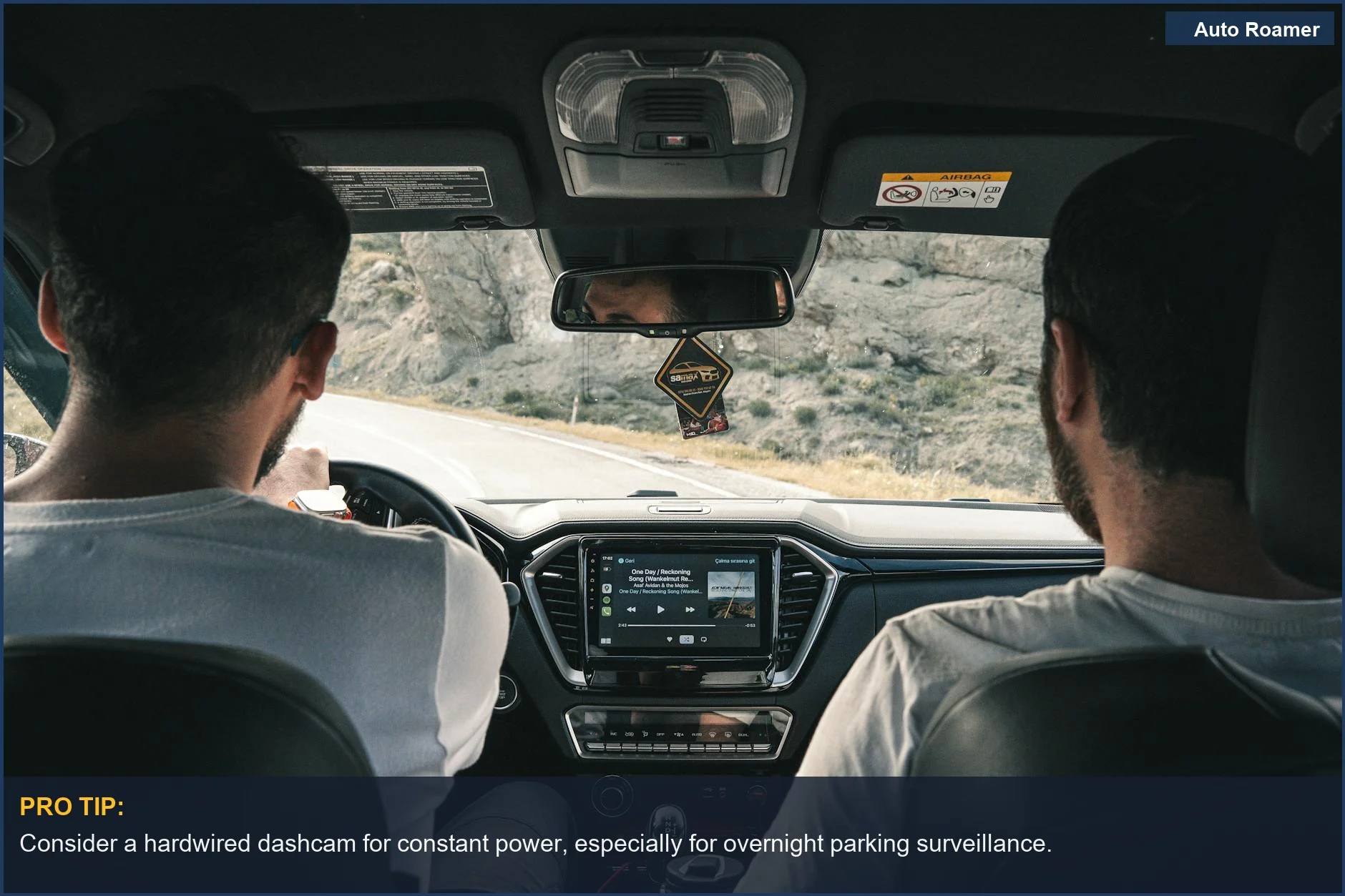 Men driving RV through scenic landscape, dashboard visible, highlighting RV electrical needs for dashcam power.