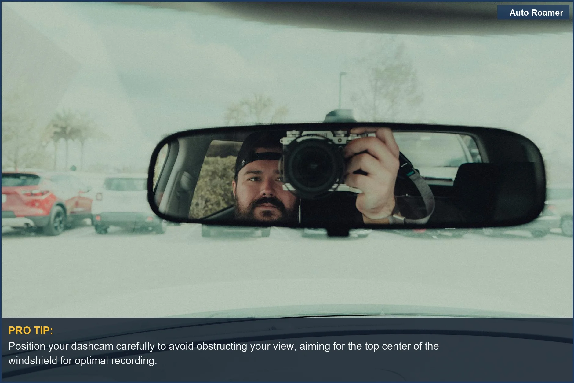 Man using a camera to capture his reflection in the rearview mirror, illustrating dashcam vs rear view mirror differences.