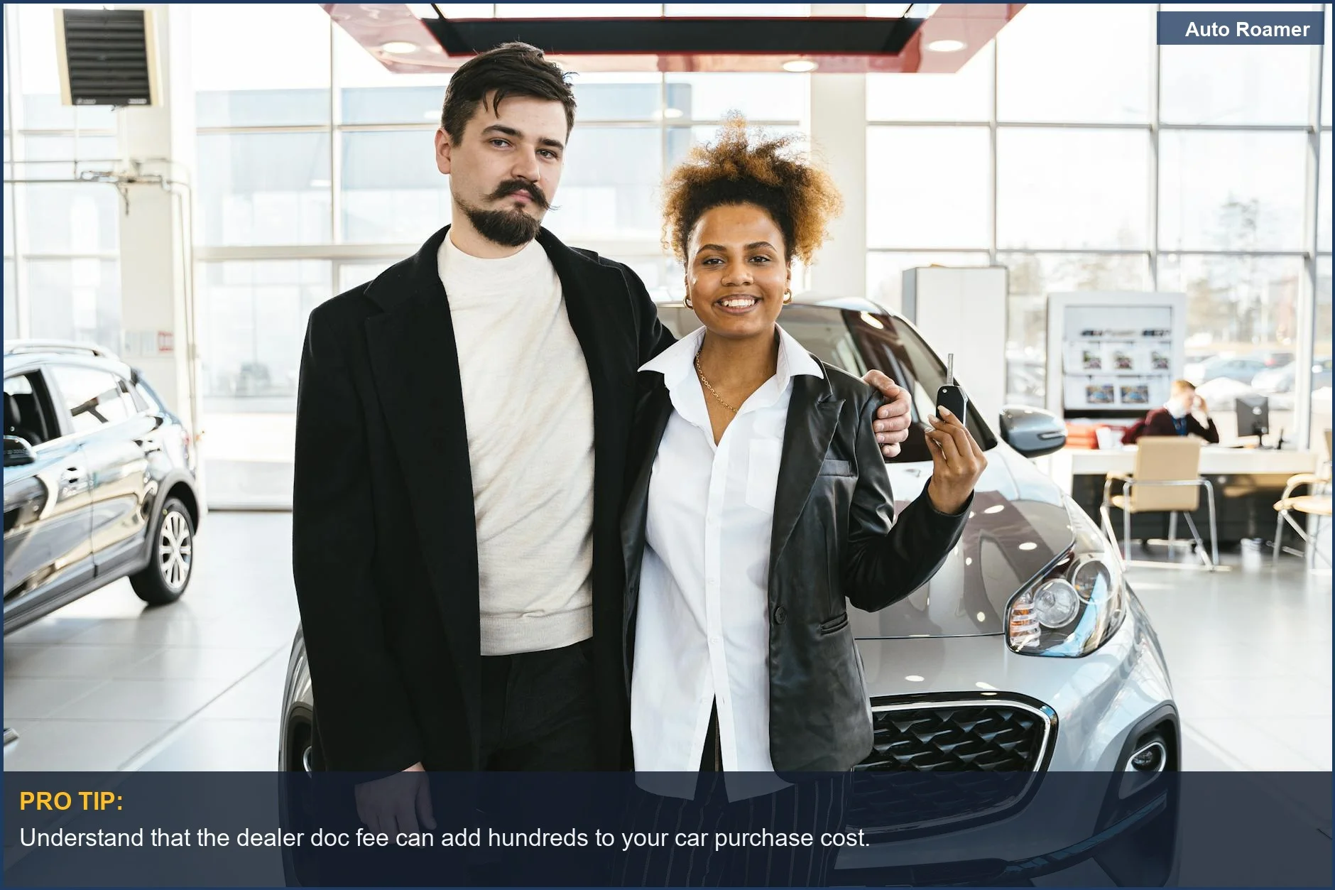 Una pareja interracial emocionada recibe las llaves de un coche nuevo en un concesionario, celebrando su compra.