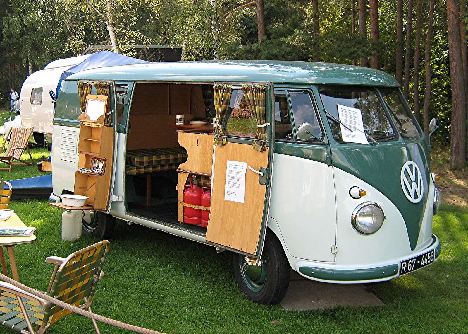 The interior of a classic VW camper van showing built-in wooden cabinetry and a bench bed, the heritage version of a DIY platform