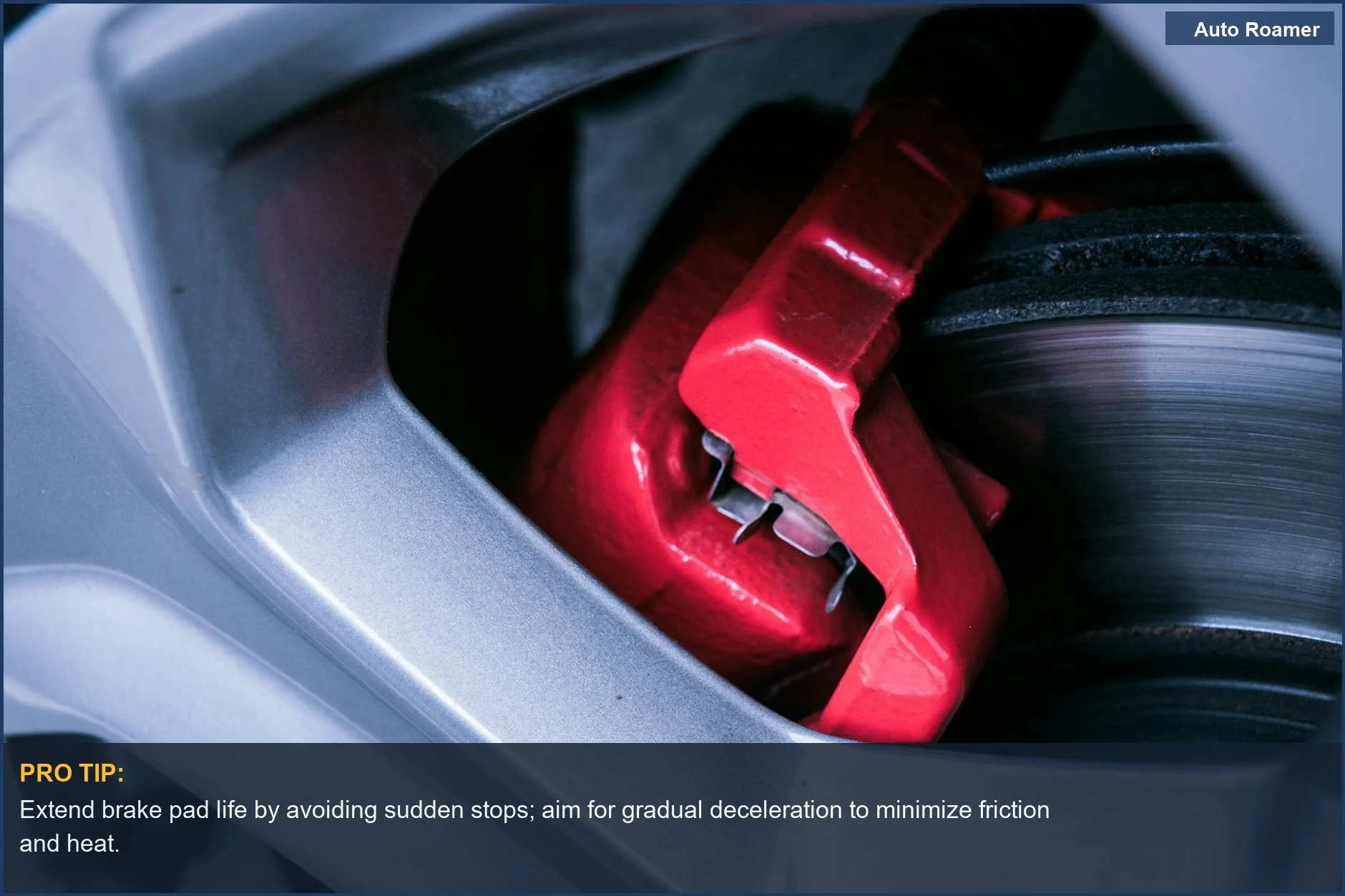 Understanding brake pad wear factors: A focused shot of a red automotive brake caliper and disc brake system.