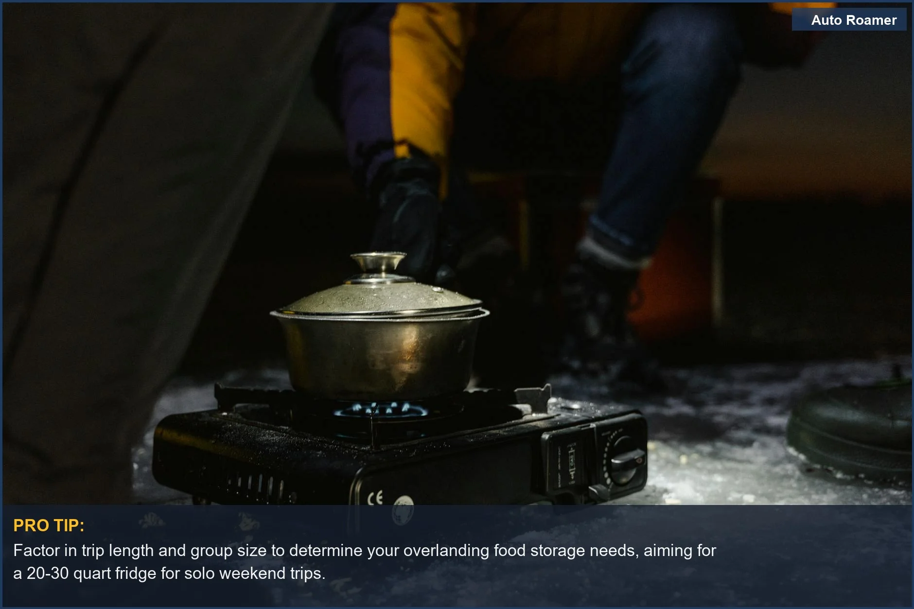 Winter camping setup with a portable stove, highlighting overlanding food storage needs in various conditions.