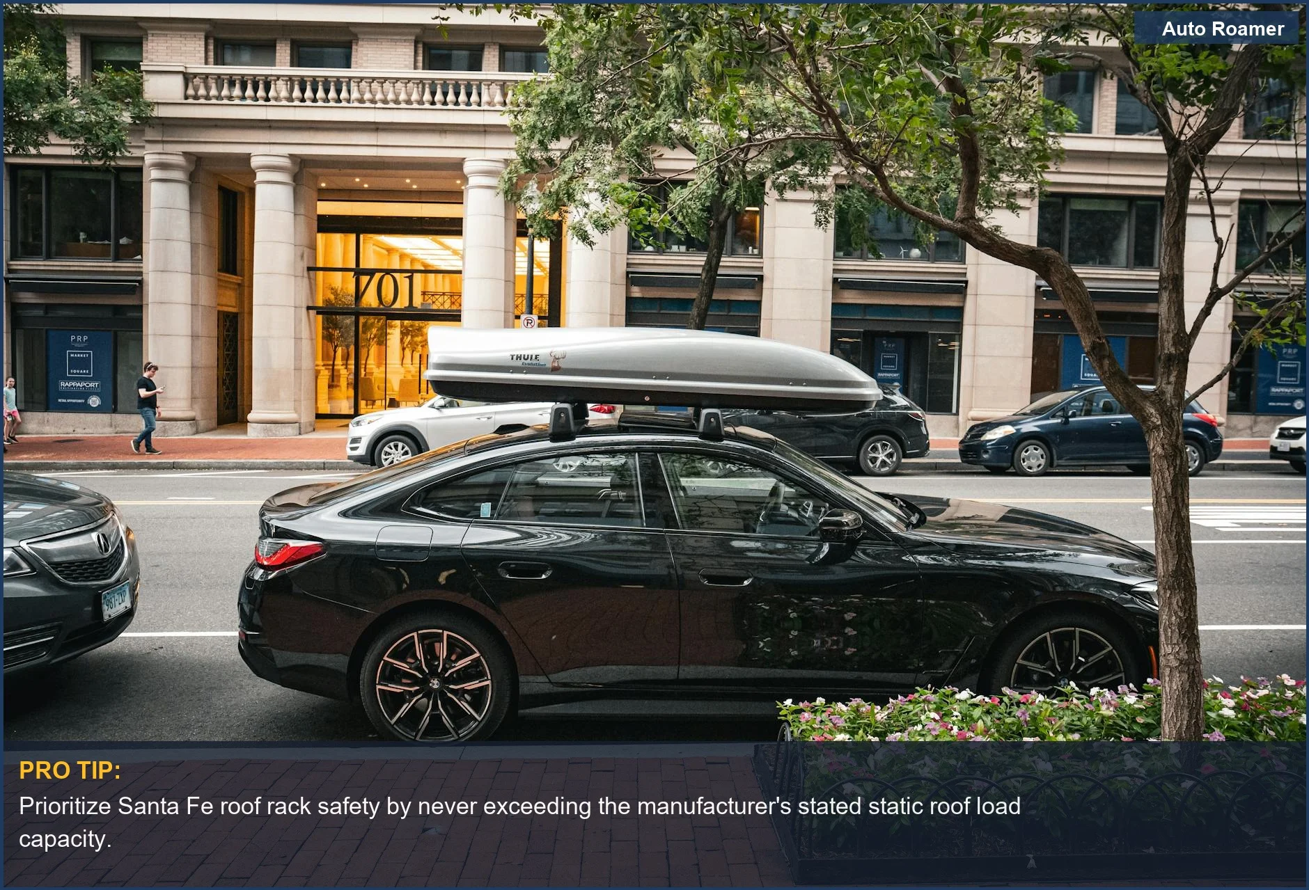 Urban city street with black sedan and rooftop cargo box, emphasizing Santa Fe roof rack safety and weight limits.
