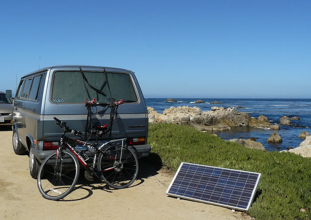 A portable solar panel set beside a camper van, the off-grid solar charging this power-station car-camping guide covers
