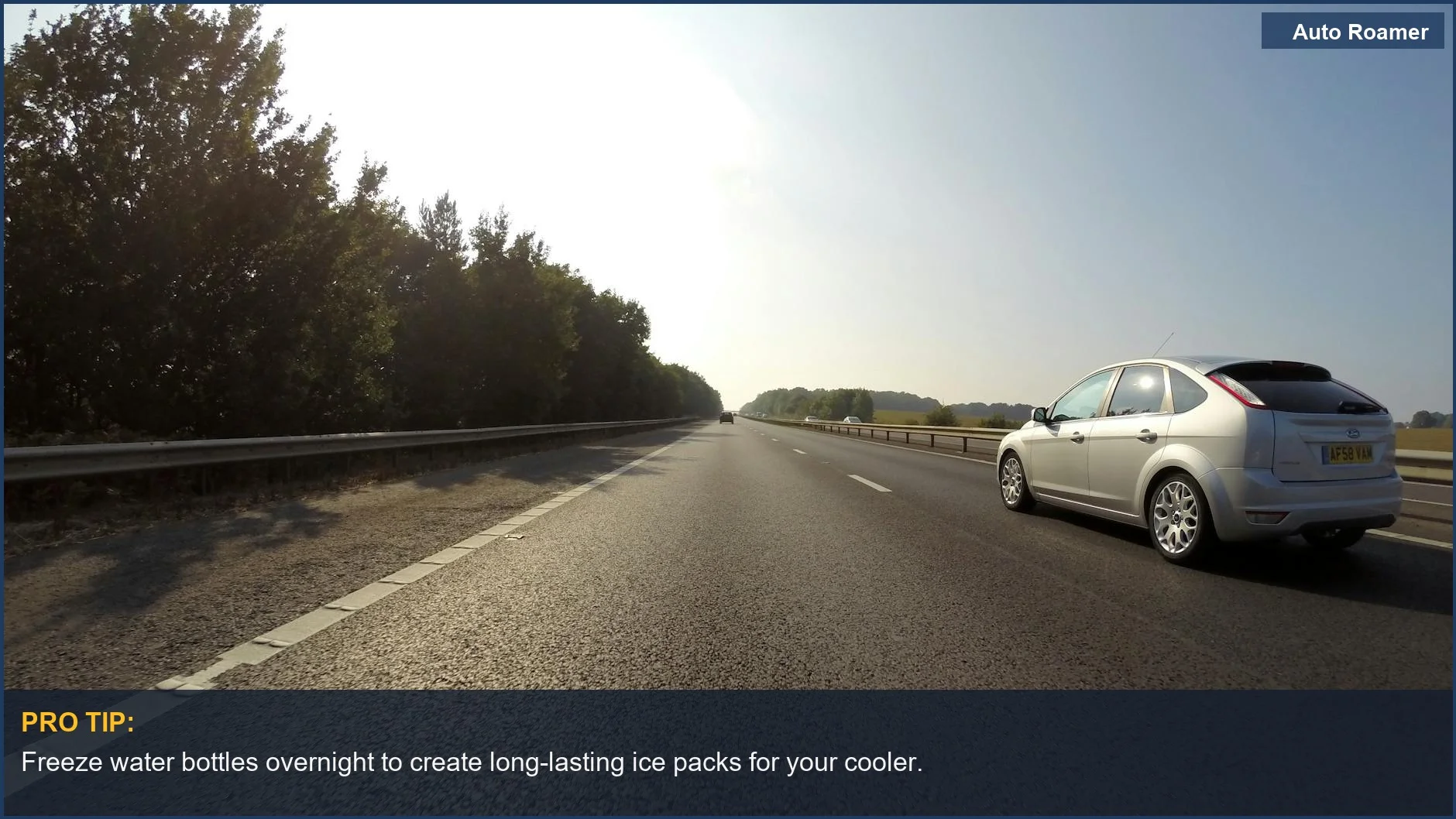 White car traveling on a clear highway through scenic trees, ideal for road trip cooling options.