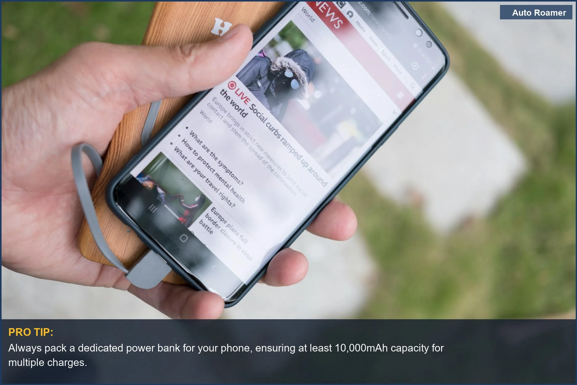 Hand holding smartphone charging from a portable power bank, demonstrating essential car camping gear for device power.