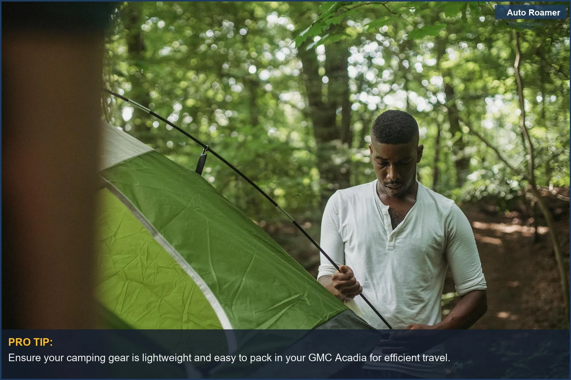 Young man setting up a camping tent in a summer forest near a GMC Acadia.