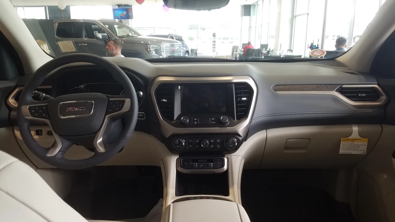 The dashboard and front cabin of a GMC Acadia, the interior this cargo-dimensions-for-sleeping guide builds a platform behind