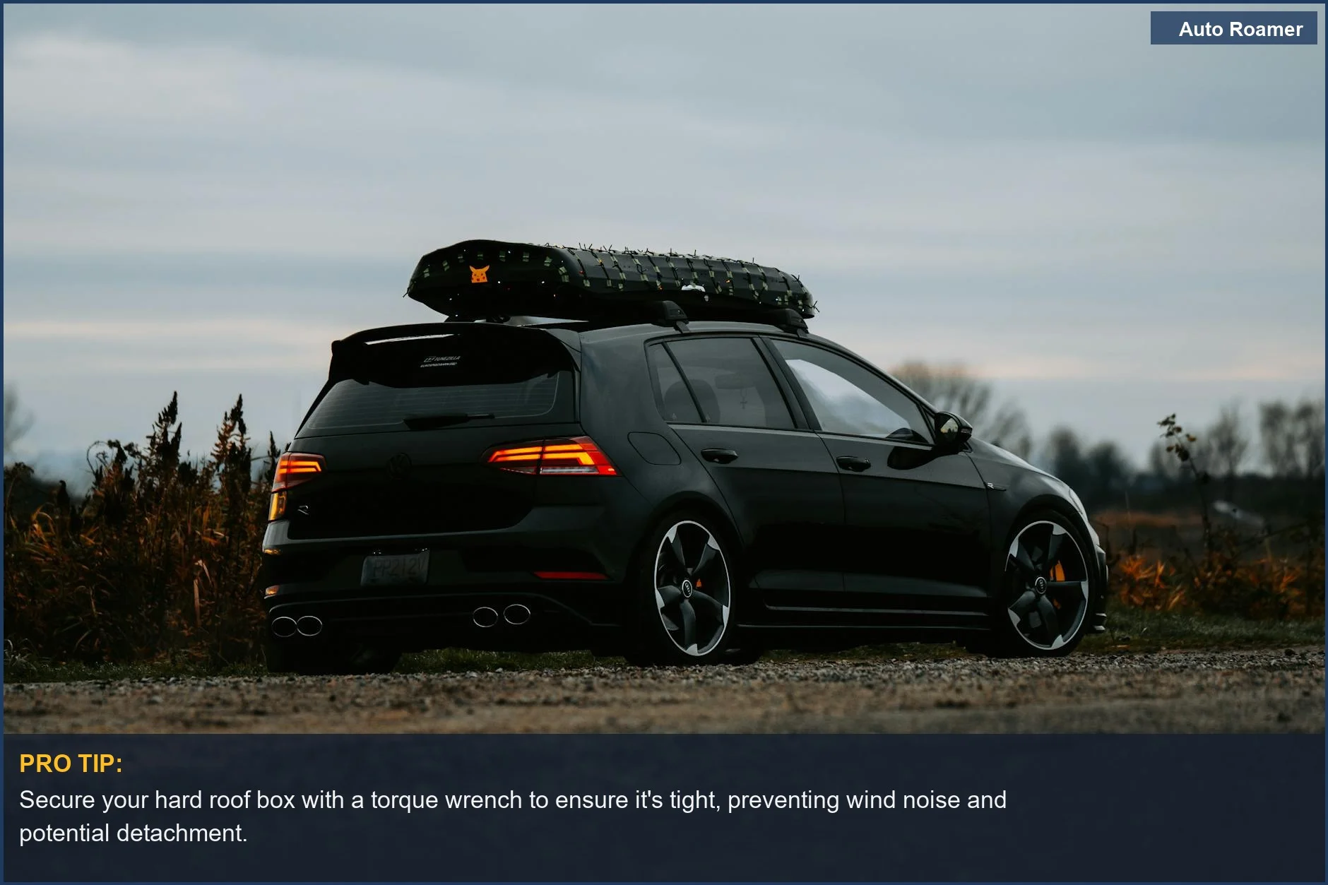 Dark hatchback with a hard roof box at twilight, showcasing an example of a roof box for road trips.