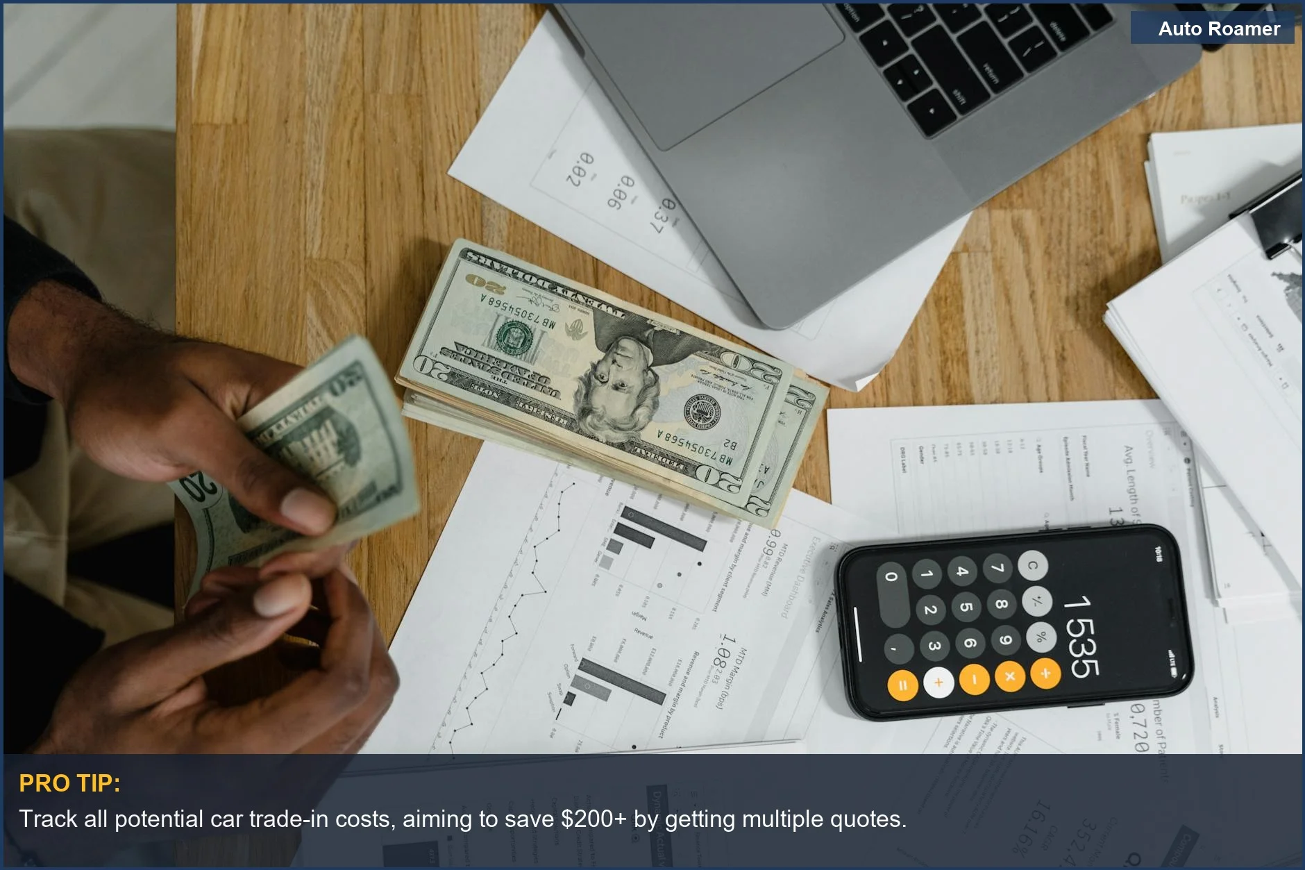 Close-up of hands counting cash with laptop and charts, demonstrating financial management for car trade-in.