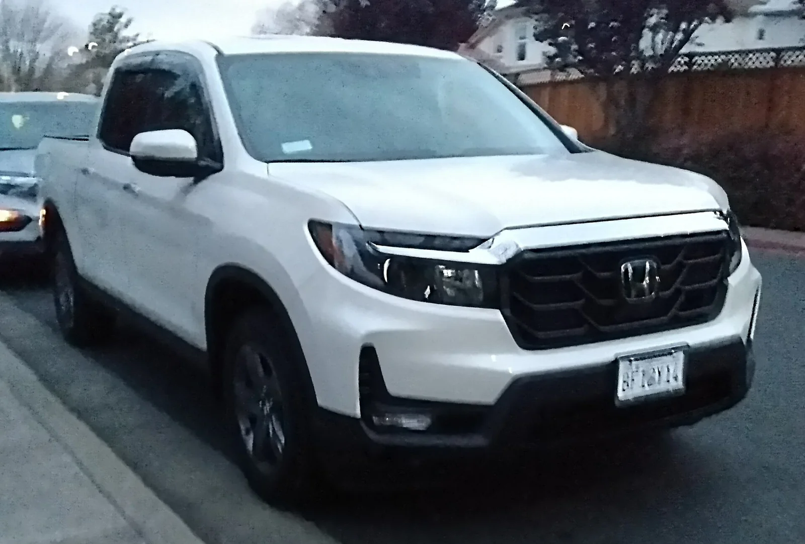 White second-generation Honda Ridgeline crew-cab pickup, the flatter bed for truck-bed camping