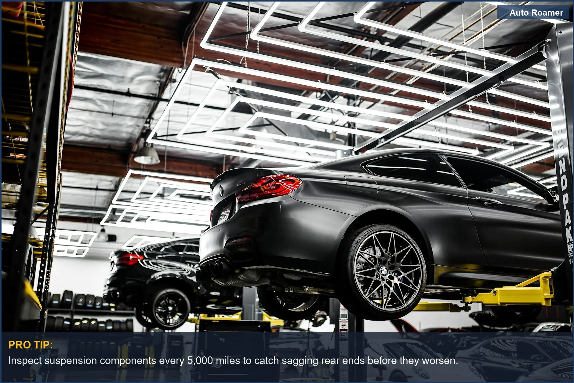 Modern car repair shop with vehicles on lifts, illustrating how car camping stresses vehicle components.