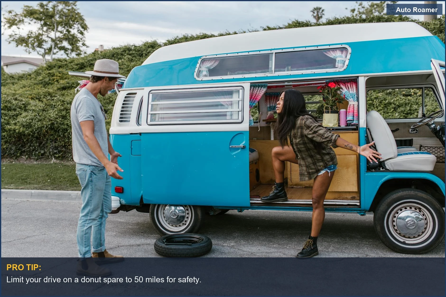 Couple arguing near vintage campervan with flat tire, discussing how long to drive on spare tire.