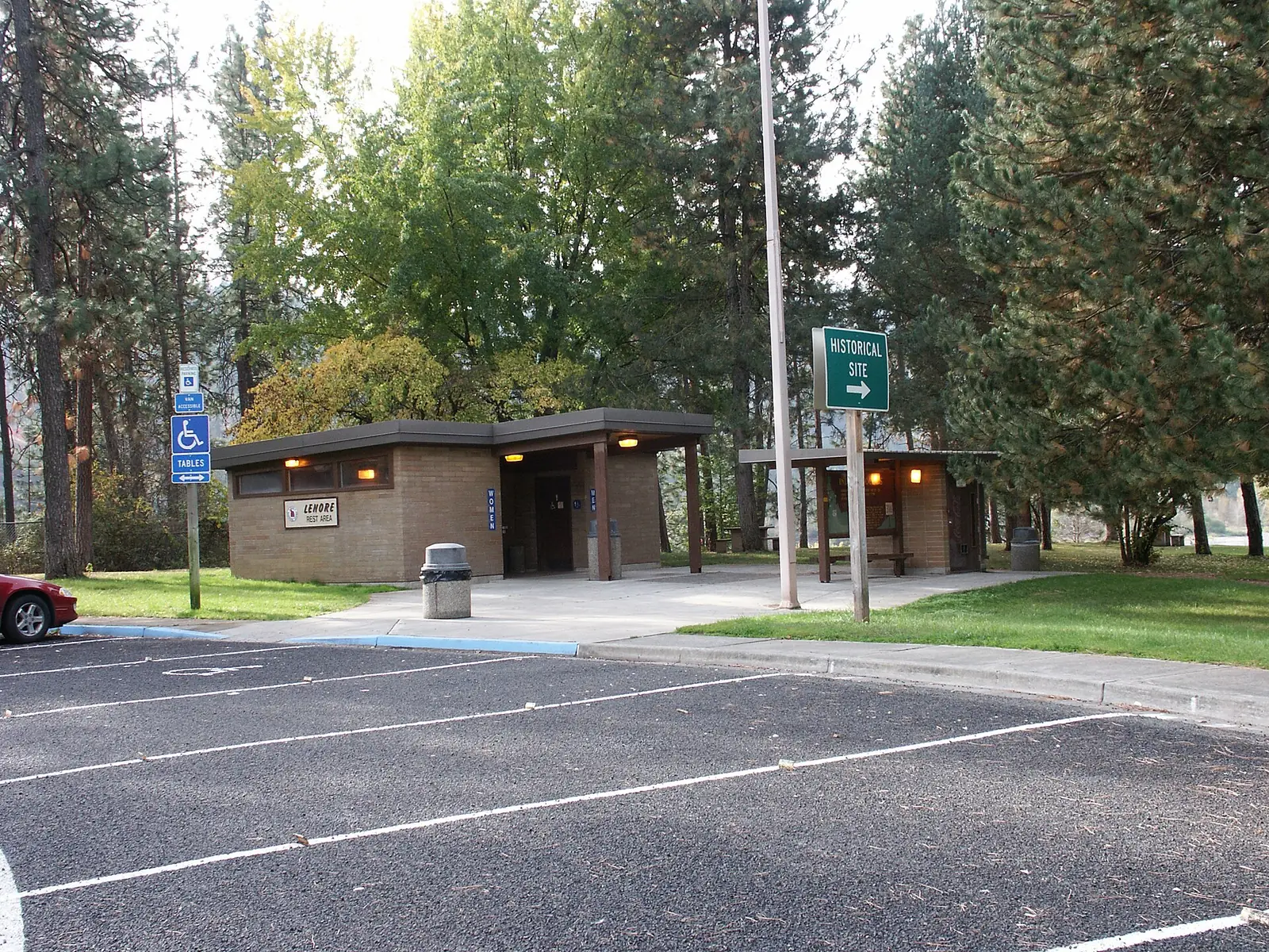 A highway rest area with parking and picnic shelters beside the road, the kind of stop used to break up a long drive with kids.