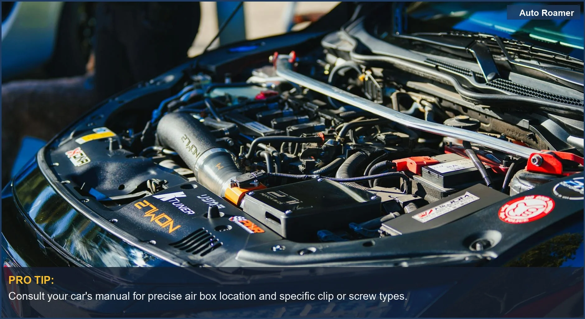 Close-up of a car engine with an open hood, showing the air box for air filter replacement.