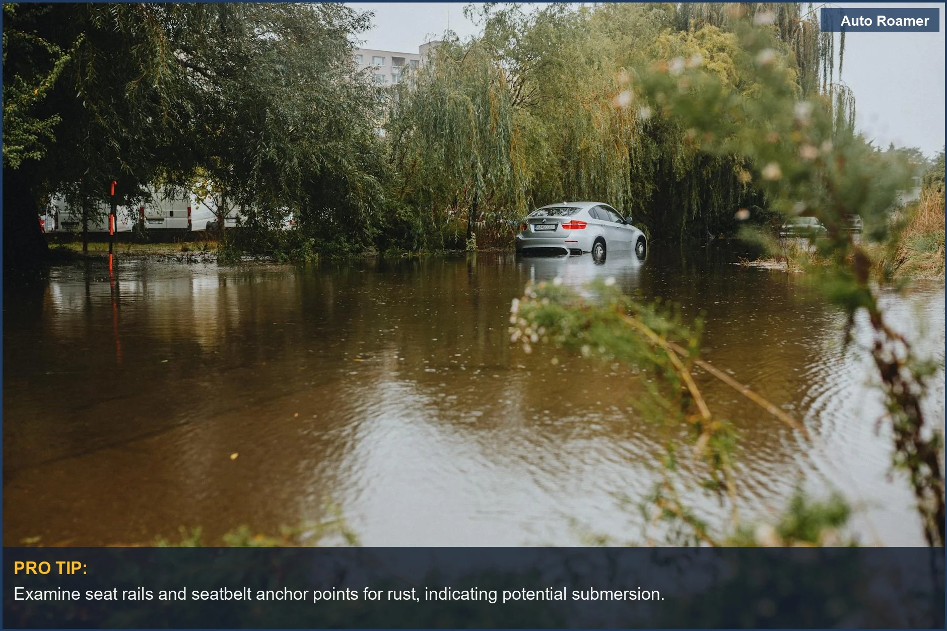 Silver car partially submerged in floodwaters, a stark reminder to check used cars for water damage before conversion.