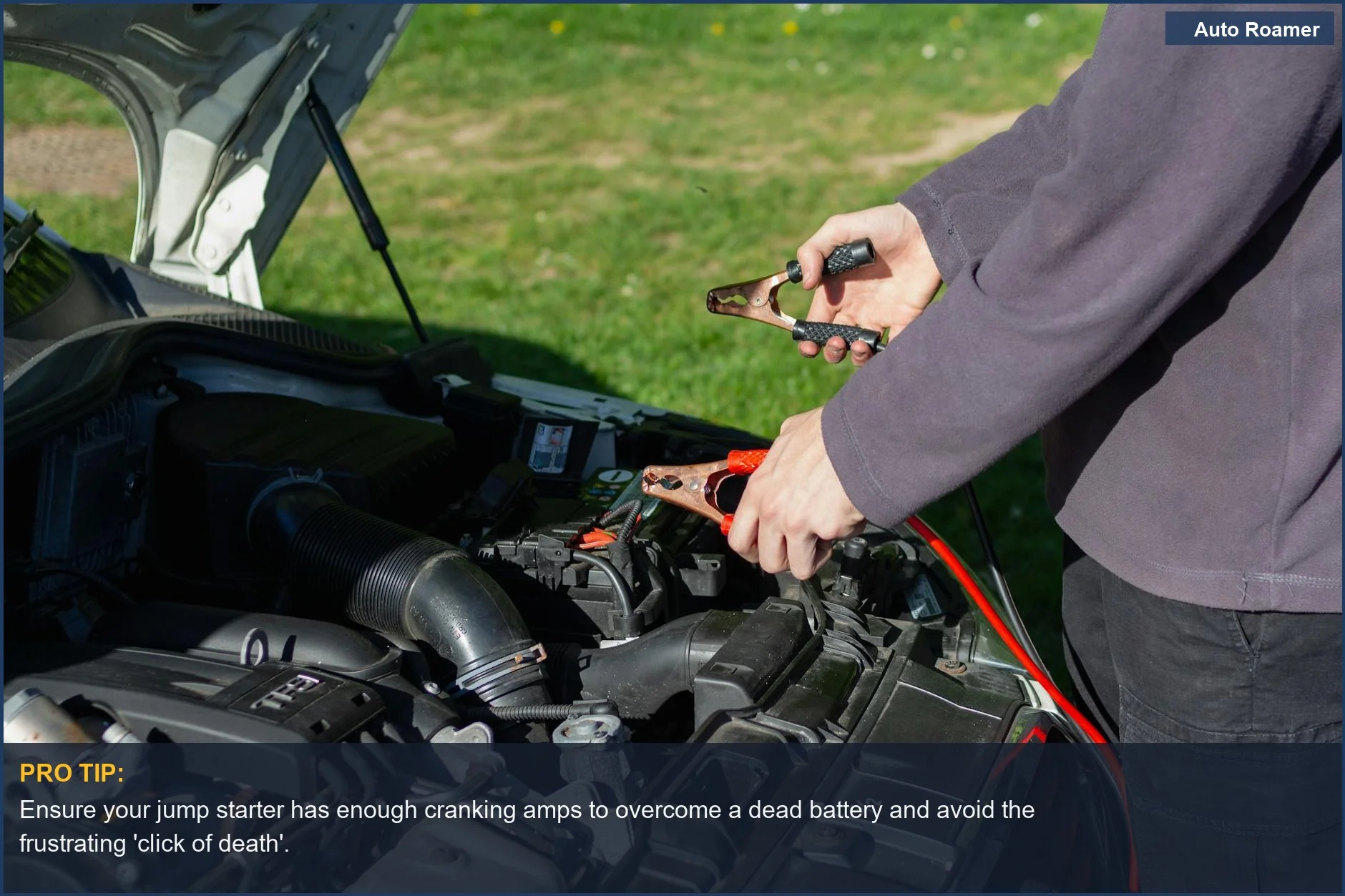 Mechanic using jumper cables to jump-start a car battery, highlighting the need for adequate cranking amps to start a dead battery.