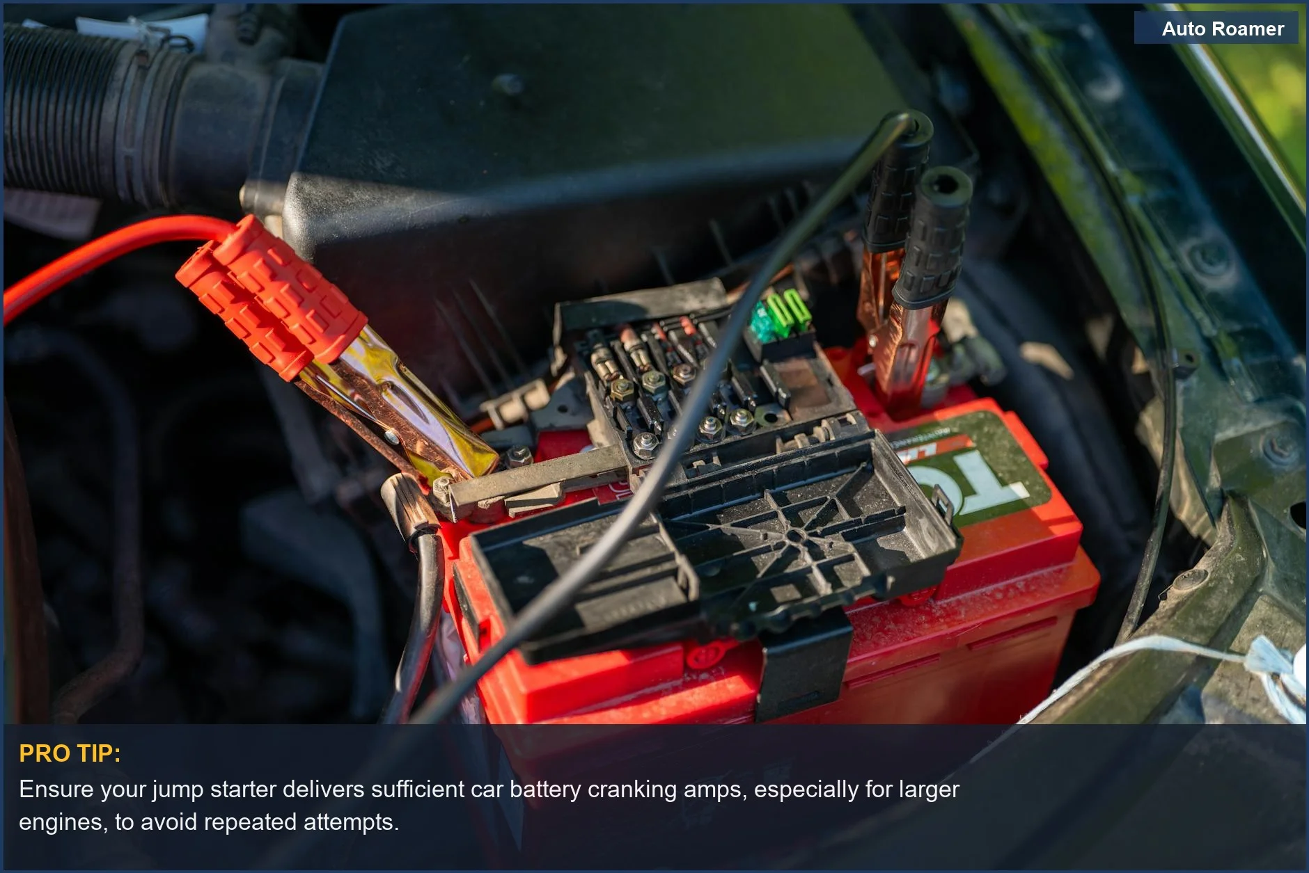 Close-up of a car battery with red jumper cables attached, illustrating the connection point for jump starting and car battery cranking amps.