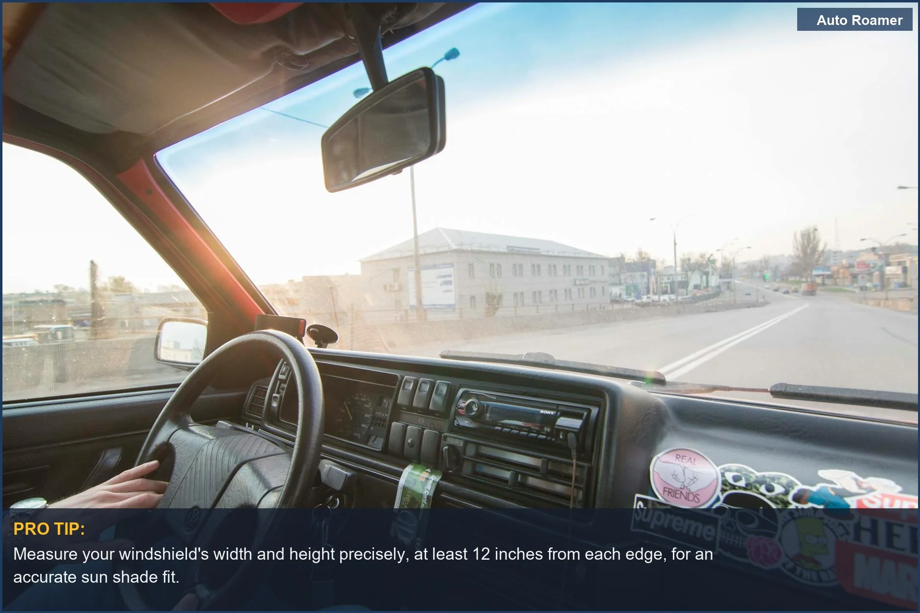 Car dashboard view with sun shining through windshield, measuring for the right sun shade size.