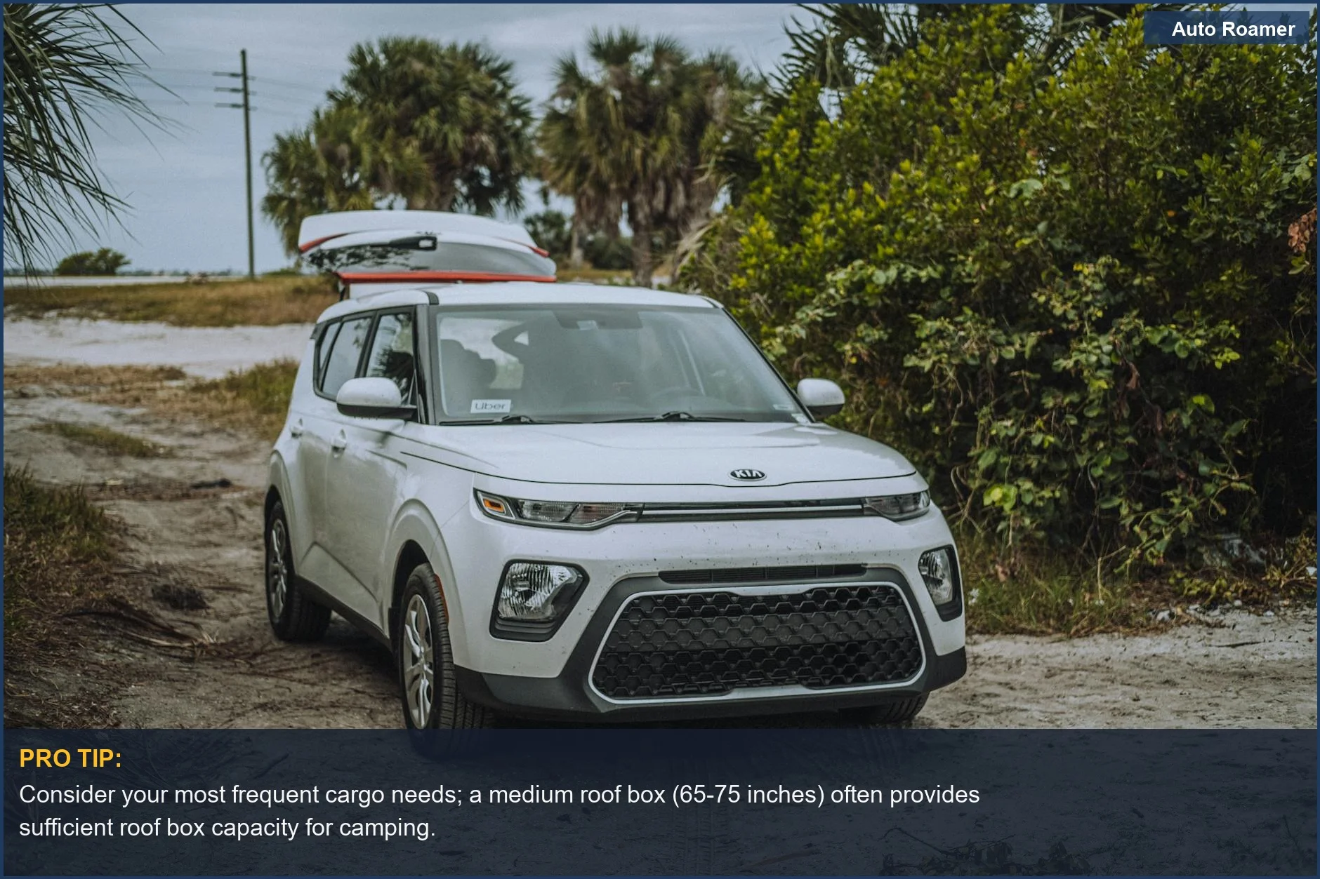 White Kia Soul with roof cargo box parked on a dirt road, ideal for understanding roof box capacity for camping trips.