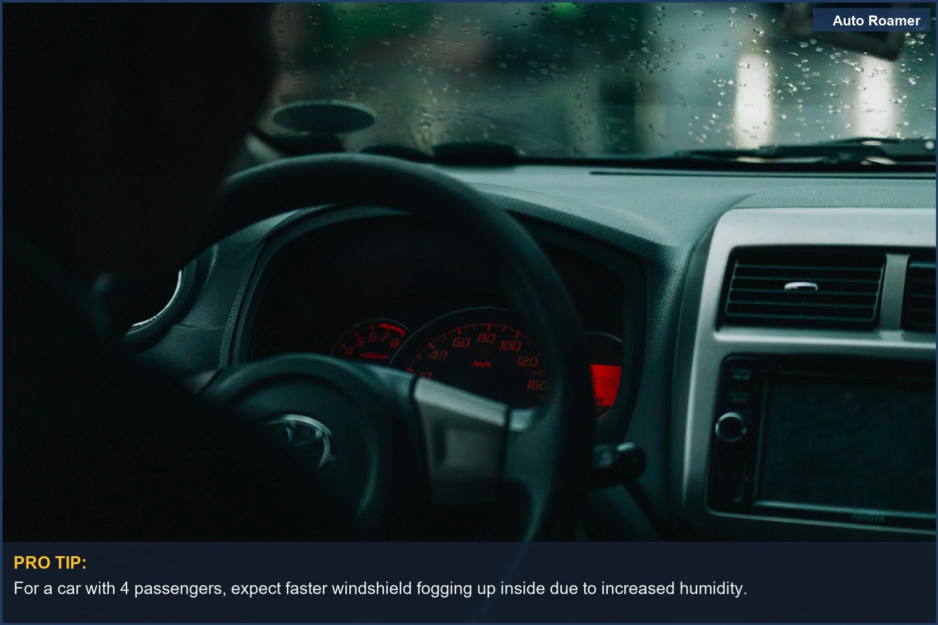 Dashboard view inside a car with raindrops on the windshield during a cold, rainy commute.