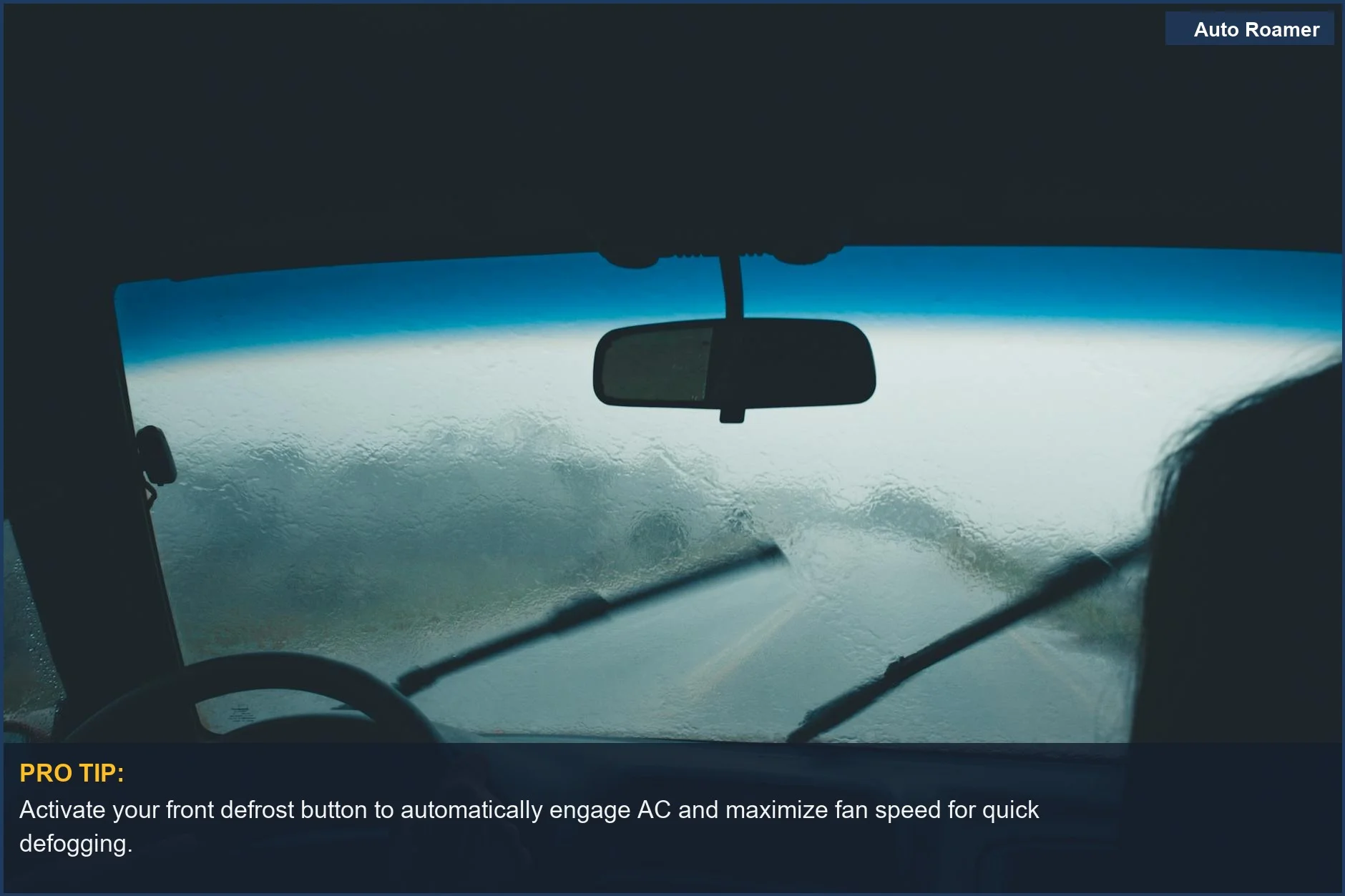 Car interior with a foggy windshield and wipers in motion during a rainy drive.