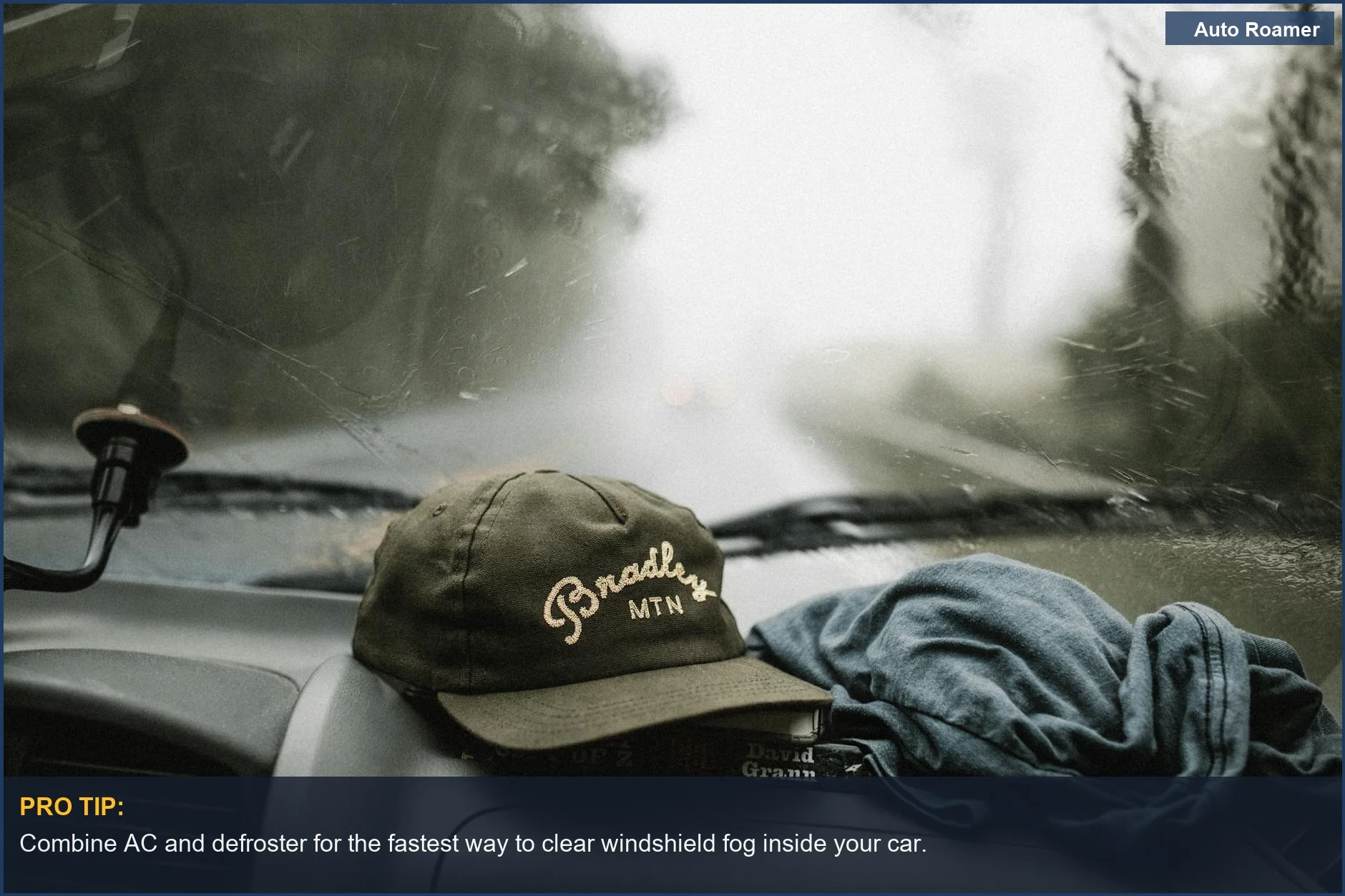 Close-up of a car interior with a foggy windshield during a rainy drive, showing the dashboard.