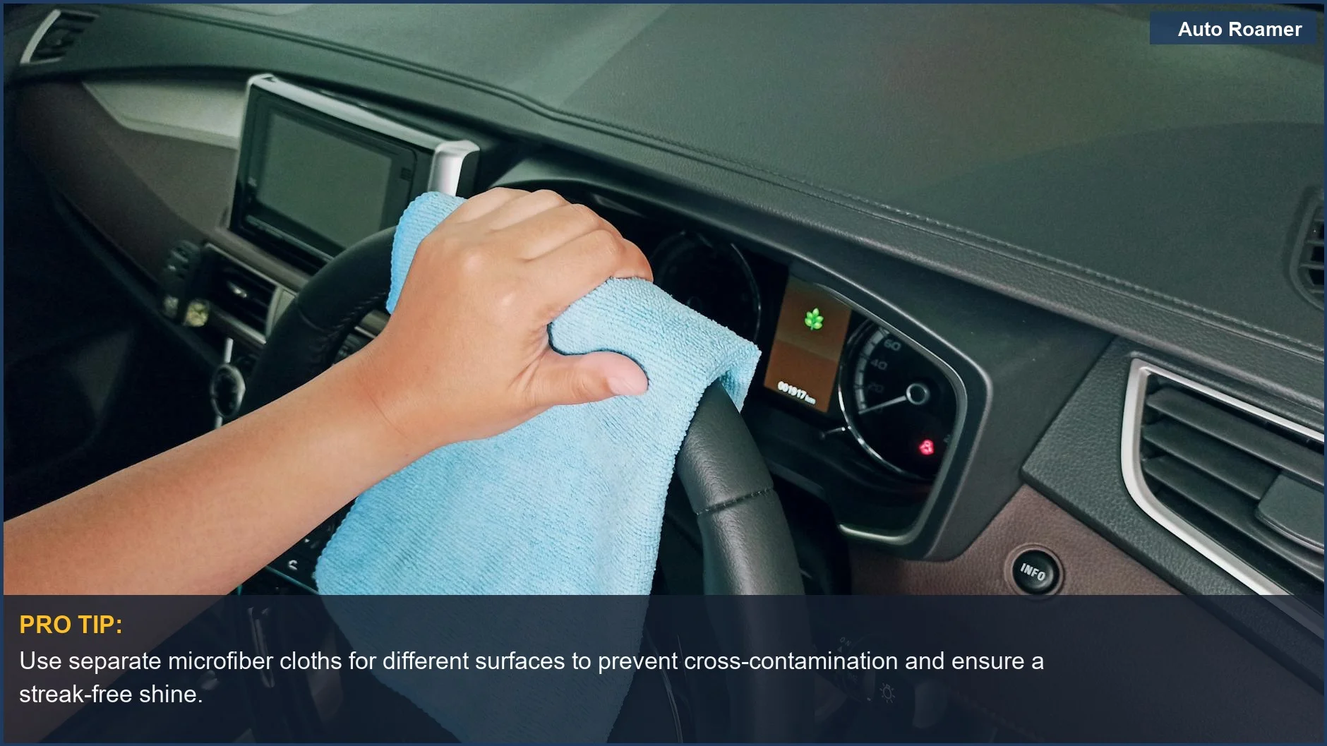 Close-up of hand wiping a car steering wheel with a microfiber cloth for a clean finish.