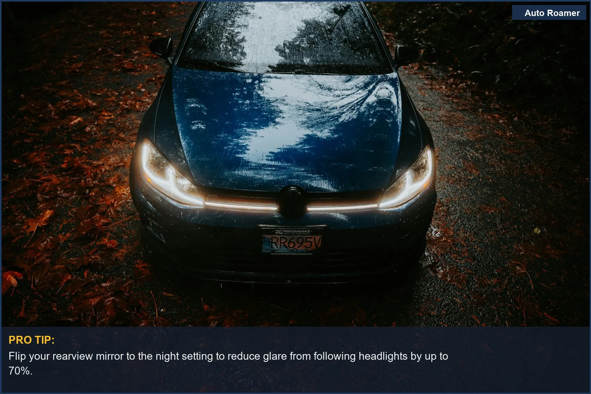 Blue car headlights shining on a wet, leaf-strewn road at night, creating a moody scene.