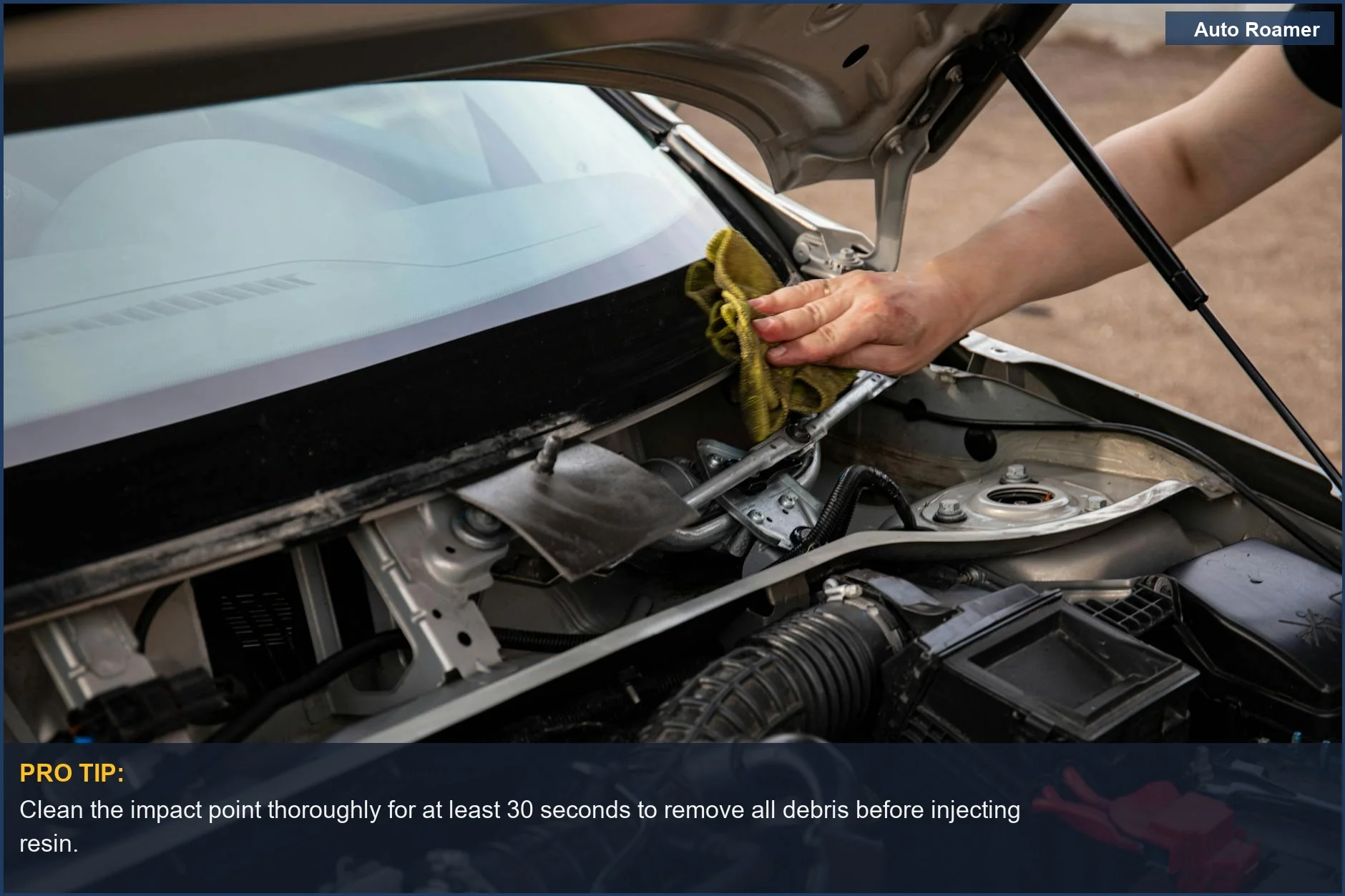Mechanic meticulously cleans a car's windshield impact point before applying a DIY repair solution.