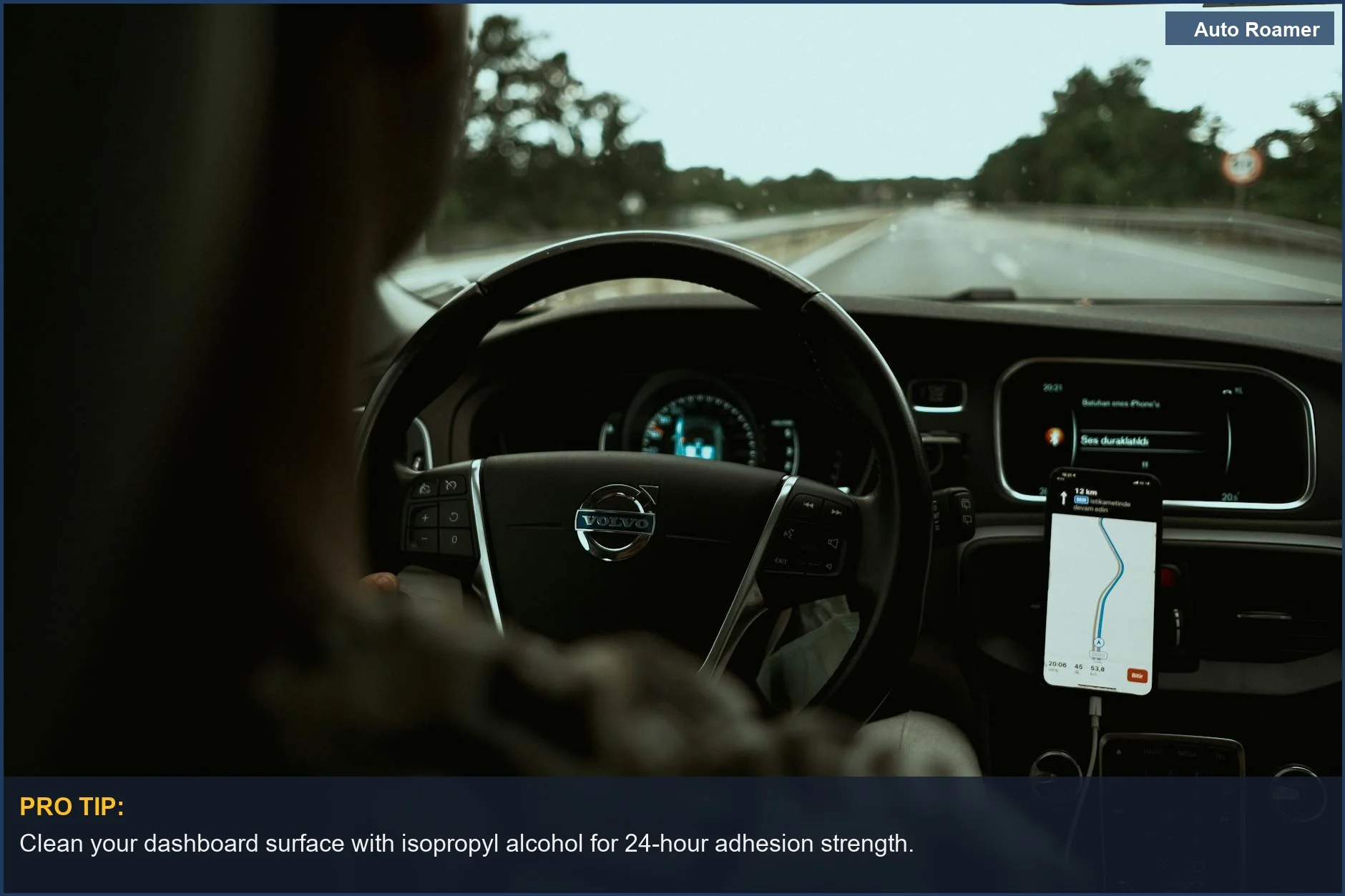 Driver using GPS on a magnetic car phone mount while driving on a highway.