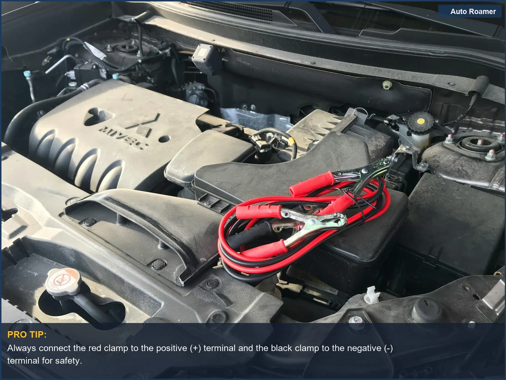 Close-up of a car engine with red jumper cables attached to the battery, essential for car maintenance.