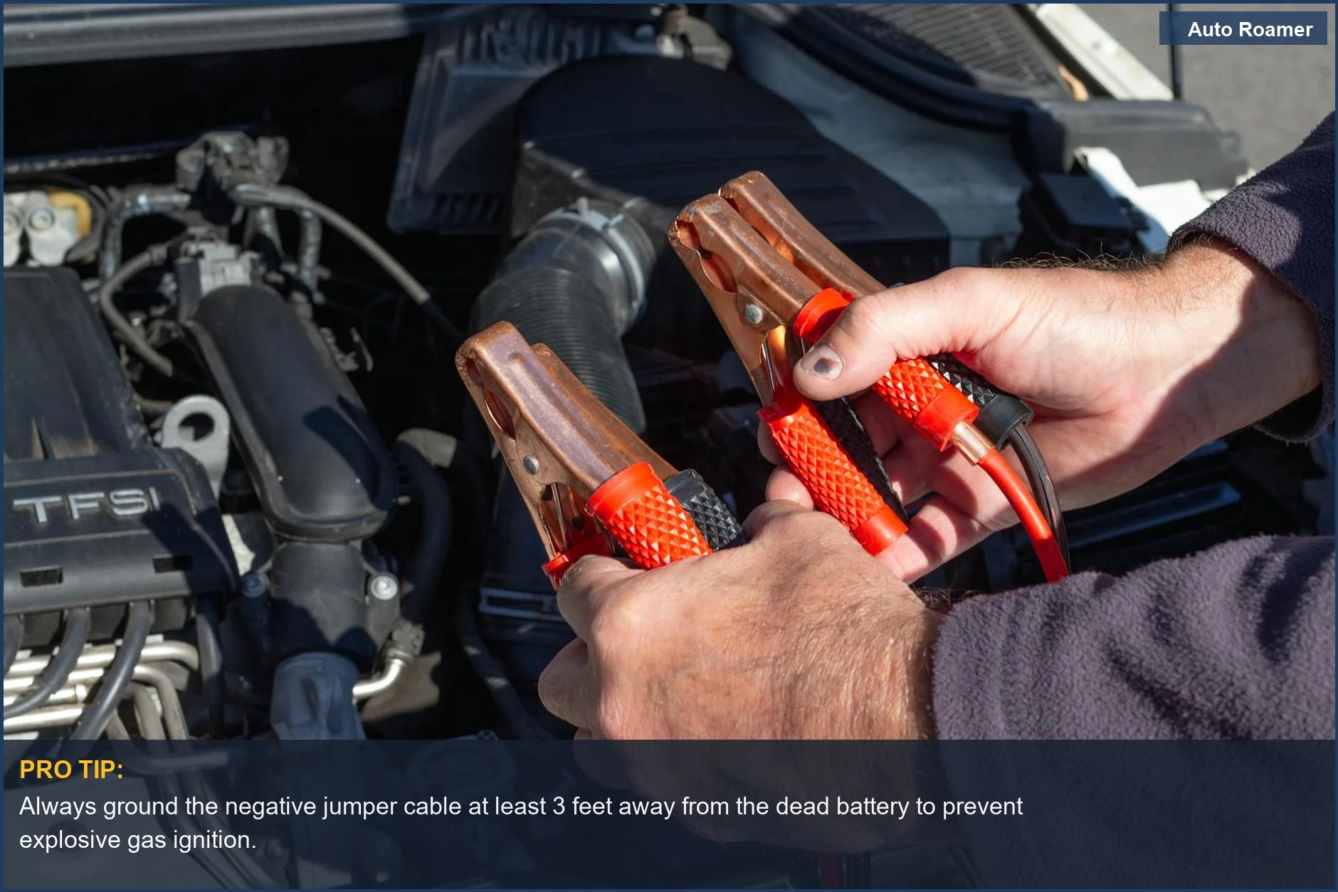 Hands holding jumper cables near a car engine, highlighting the risks and signals when jump starting a car.