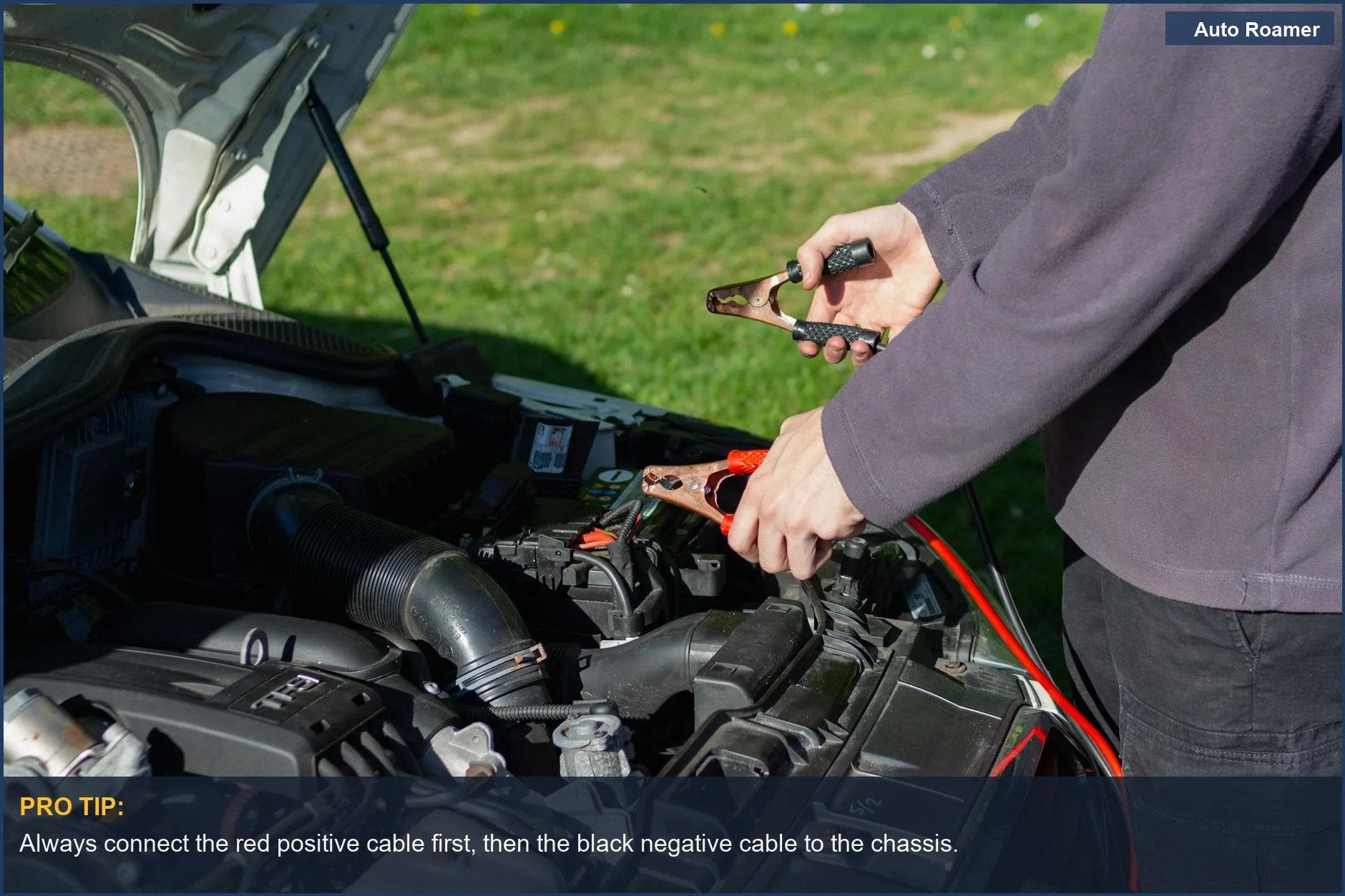 Close-up of mechanic connecting jumper cables to a car battery to jump-start it.