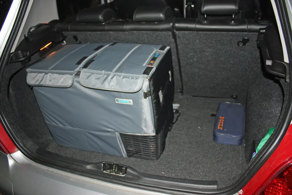 A 12V fridge sitting in a car boot, the kind of portable fridge this guide keeps from draining your car battery