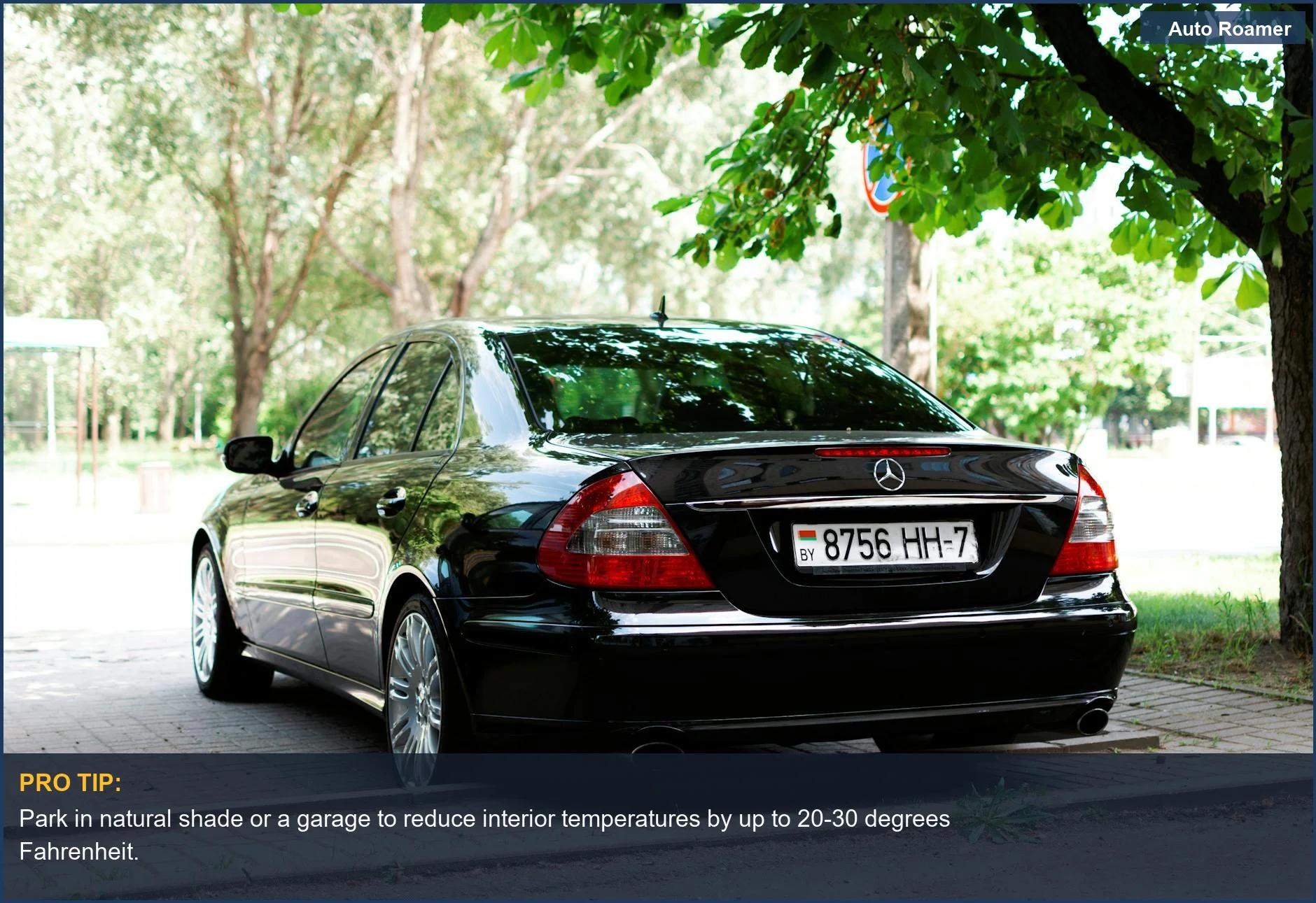 An elegant black Mercedes W211 parked under lush green trees, demonstrating how to keep car cool while parked in summer.
