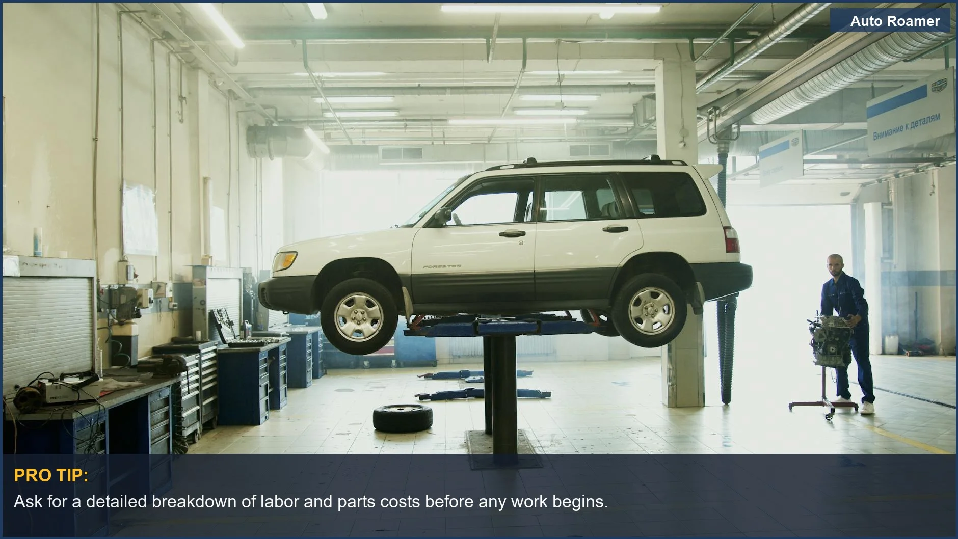 Mechanic explaining car repairs on a lift, crucial for knowing if your mechanic is overcharging you.