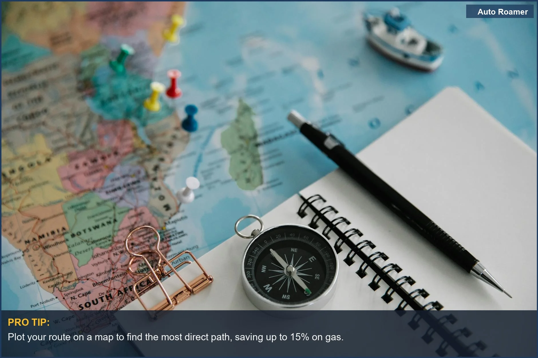 Planning a budget road trip across the US with map, compass, and notebook.