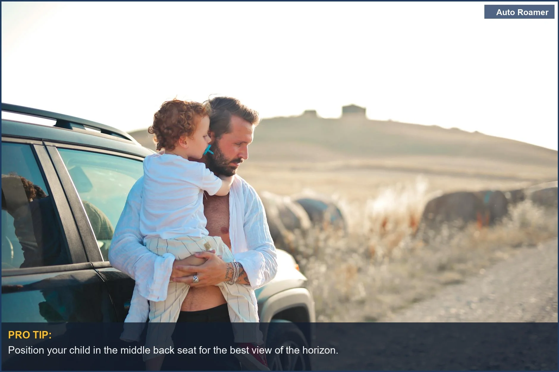 Father holds son by a car, showcasing family bonding in a countryside setting while preventing car sickness in kids.