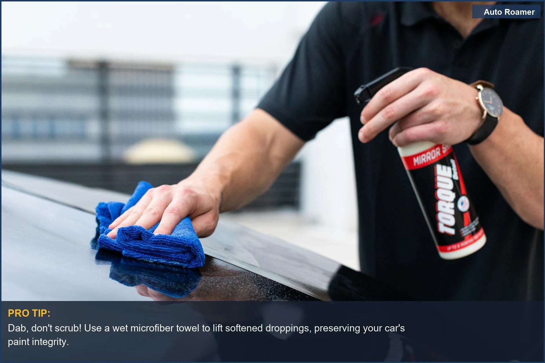 Hands using a plush microfiber cloth and spray cleaner to gently lift bird droppings from car paint.