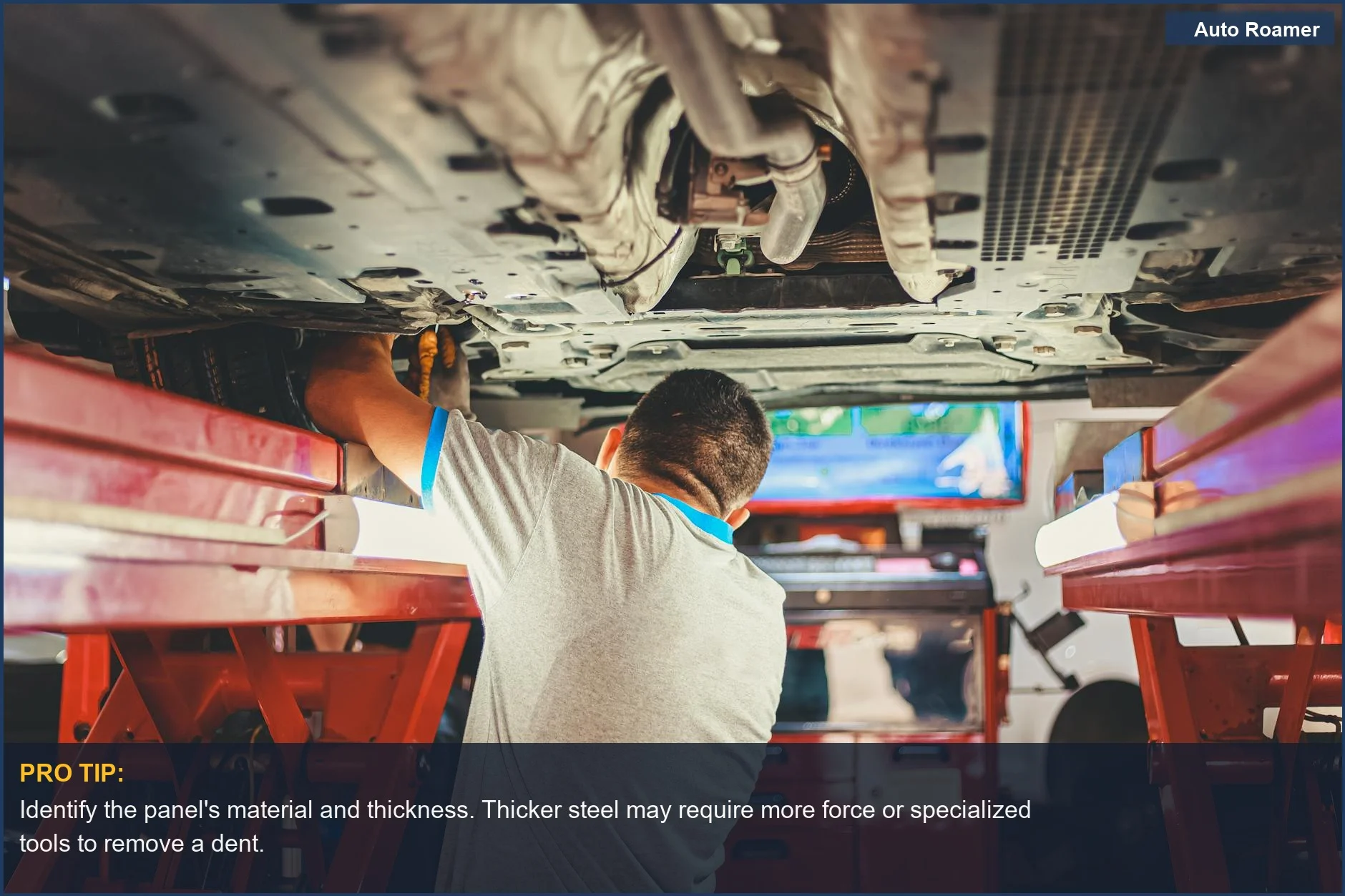 Mechanic under a lifted car, illustrating the importance of understanding car body panels for dent repair.