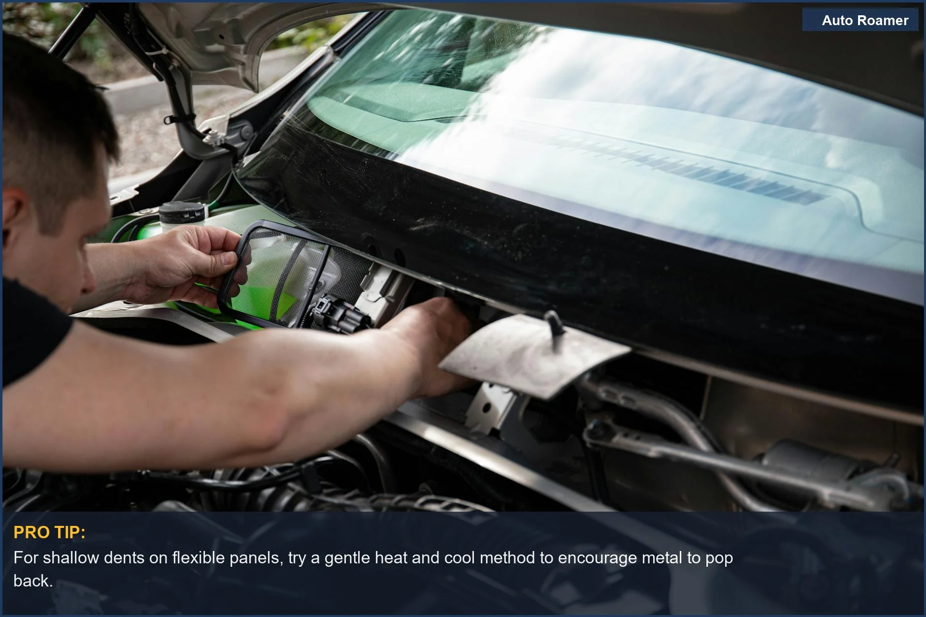 Hands of a mechanic fixing a car engine, relevant to removing small dents on a car's body.