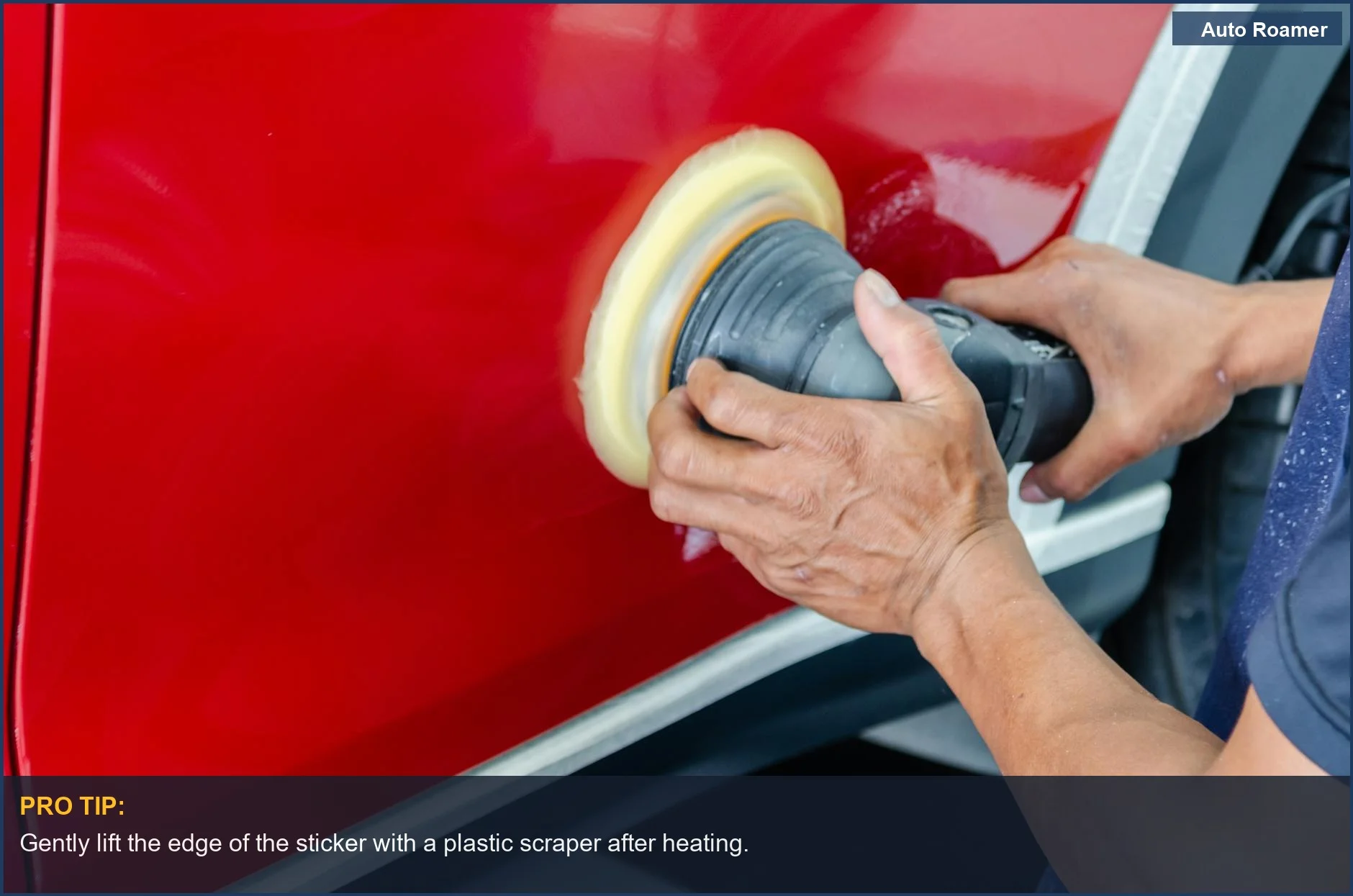 Close-up of a worker warming a car decal with a hairdryer before removal.